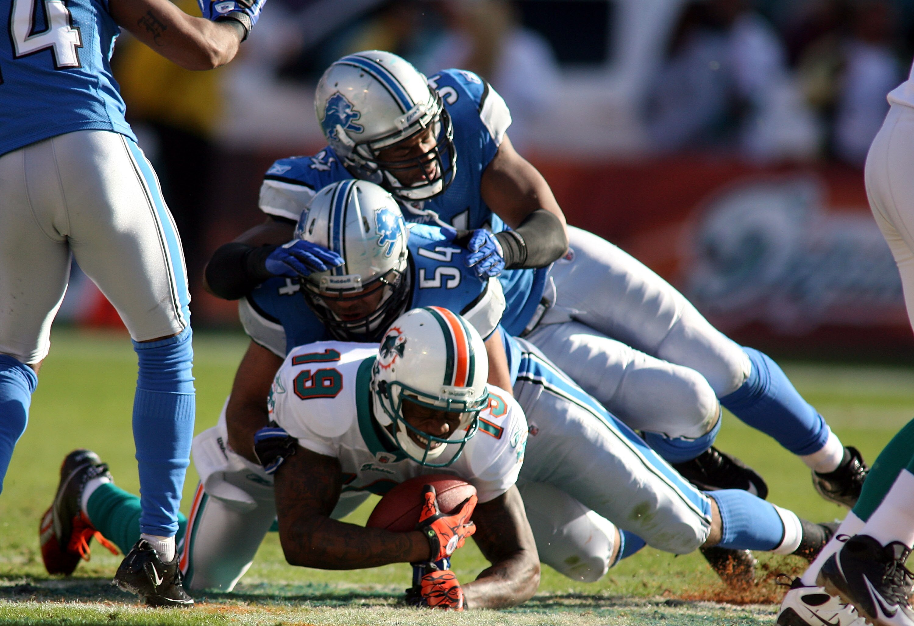 MIAMI - DECEMBER 26: Wide receiver Brandon Marshall #19 of the Miami Dolphins is brought down by linebacker DeAndre Levy #54 of the Detroit Lions at Sun Life Stadium on December 26, 2010 in Miami, Florida. The Lions defeated the Dolphins 34-27.  (Photo by