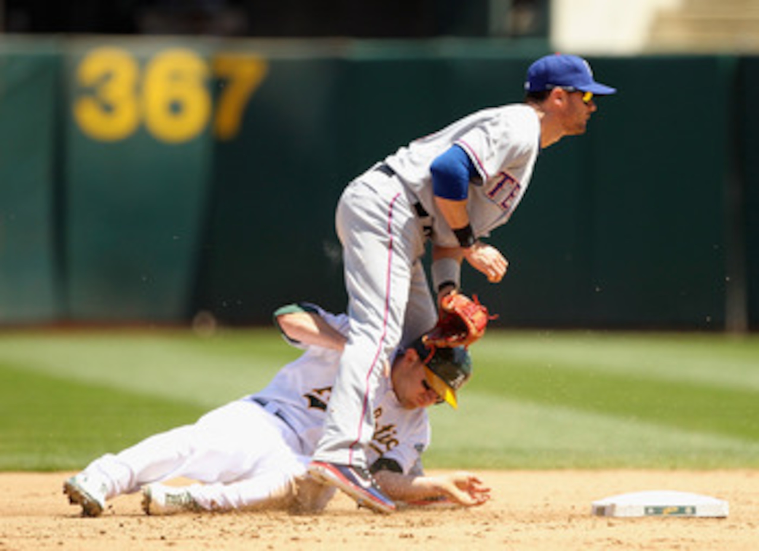 OAKLAND, CA - MAY 02:  Cliff Pennington #2 of the Oakland Athletics slides through the legs of Michael Young #10 of the Texas Rangers after he was forced out at second base at Oakland-Alameda County Coliseum on May 2, 2011 in Oakland, California.  (Photo 