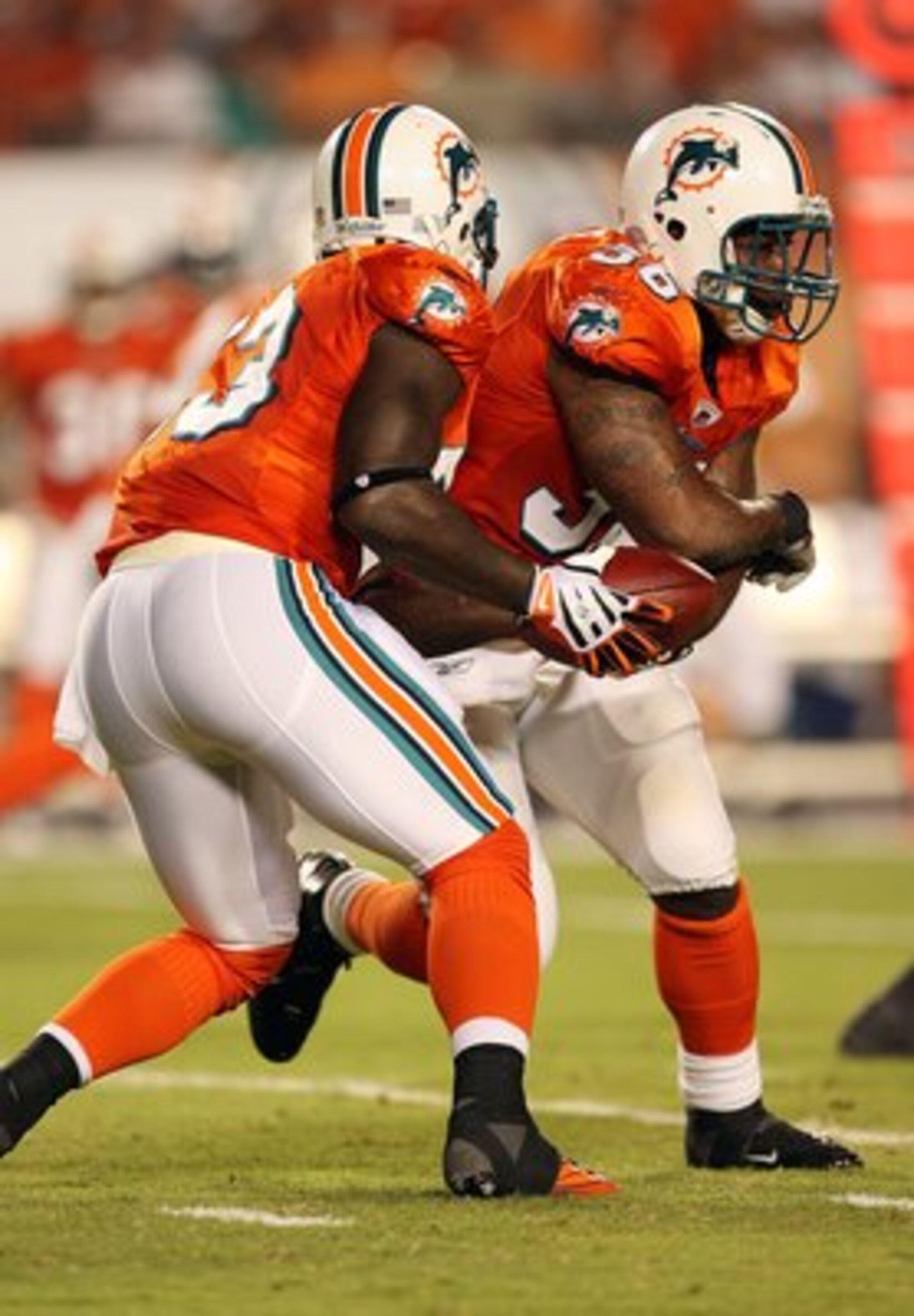 MIAMI - OCTOBER 12:  Running back Ronnie Brown #23 of the Miami Dolphins fakes a hand-off to fullback Lousaka Polite #36 against the New York Jets at Land Shark Stadium on October 12, 2009 in Miami, Florida. The Dolphins defeated the Jets 31-27.  (Photo b