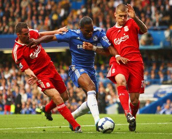 LONDON - OCTOBER 04:  Martin Skrtel (R) and Jamie Carragher of Liverpool (L) tussle with Didier Drogba of Chelsea during the Barclays Premier League match between Chelsea and Liverpool at Stamford Bridge on October 4, 2009 in London, England.  (Photo by I