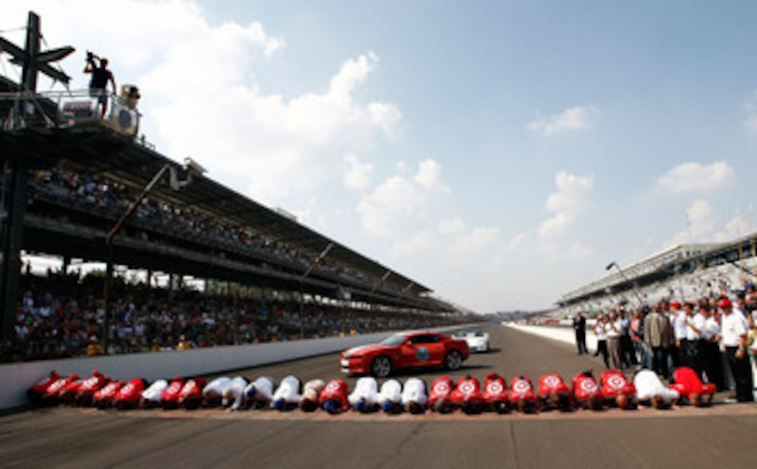 INDIANAPOLIS - MAY 30:  Dario Franchitti of Scotland, driver of the #10 Target Chip Ganassi Racing Dallara Honda, clebrates with his team by kissing the bricks after winning the IZOD IndyCar Series 94th running of the Indianapolis 500 at the Indianapolis