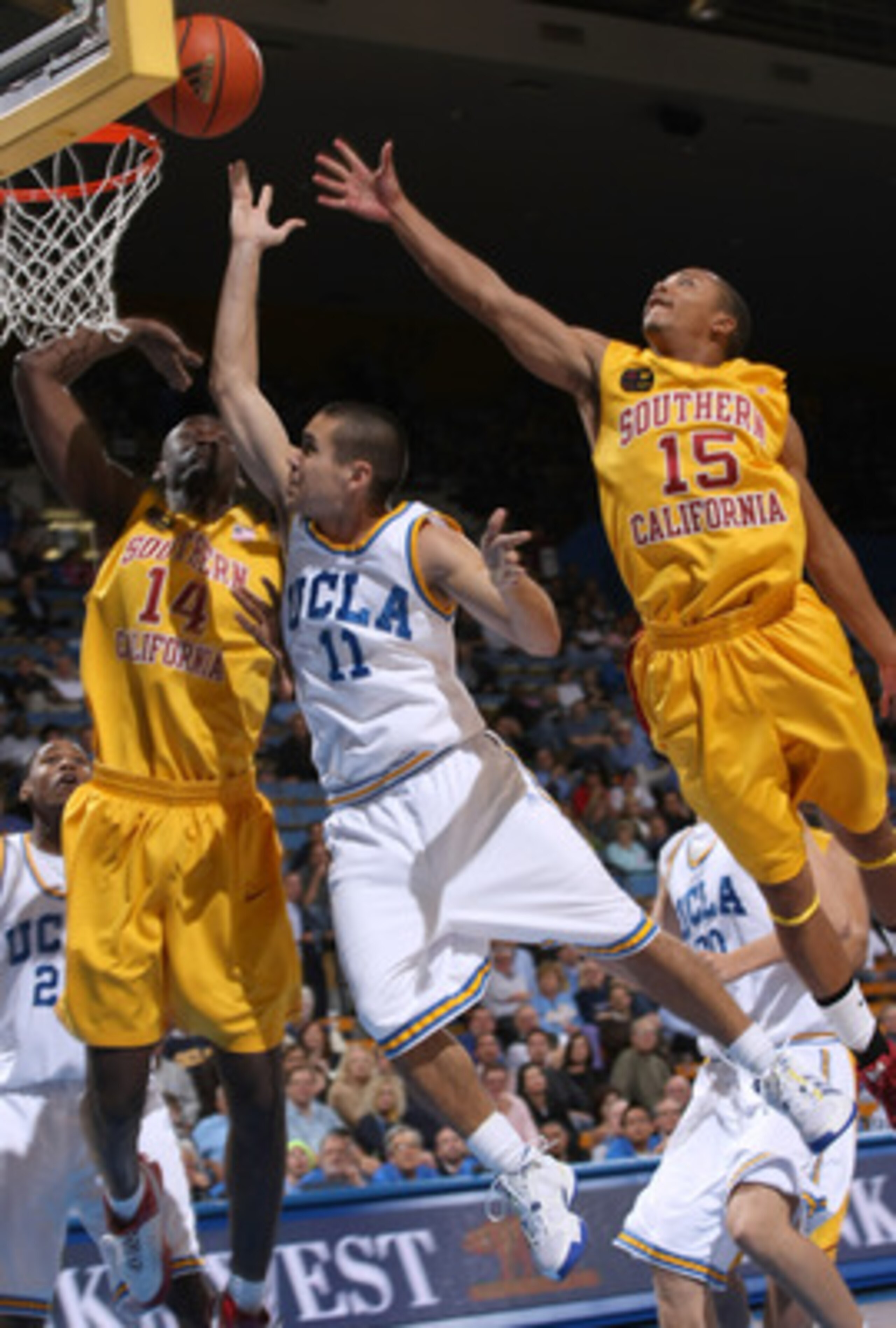 WESTWOOD, CA - FEBRUARY 4:  Spencer Soo #11 of the UCLA Bruins shoots between Mamadou Diarra #14 and Percy Miller #15 of the USC Trojans on February 4, 2009 at Pauley Pavillion in Westwood, California.   UCLA won 76-60.   (Photo by Stephen Dunn/Getty Imag