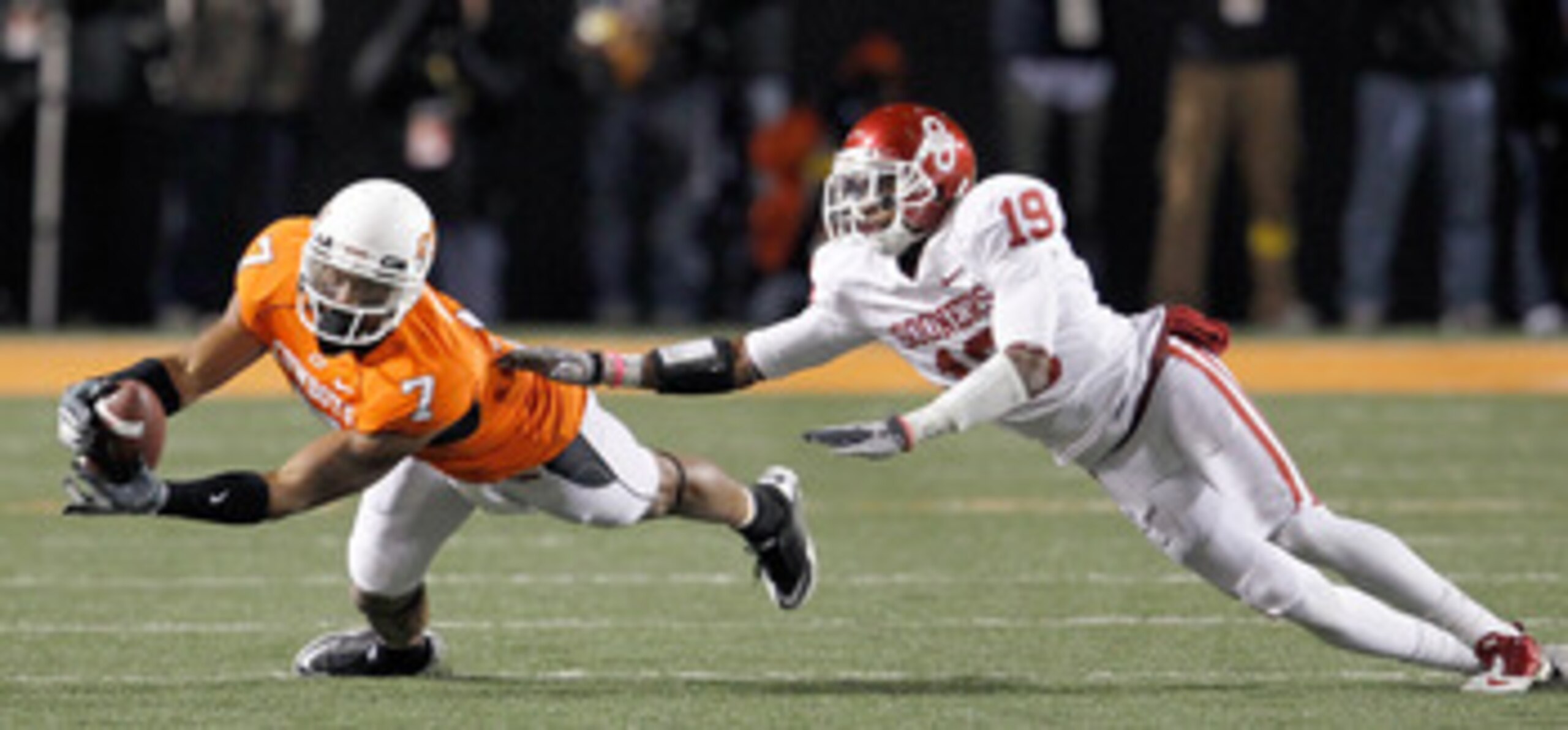 STILLWATER, OK - NOVEMBER 27:  Receiver Michael Harrison #7 of the Oklahoma State Cowboys pulls in a pass against defensive back Demontre Hurst #19 of the Oklahoma Sooners at Boone Pickens Stadium on November 27, 2010 in Stillwater, Oklahoma.  The Sooners