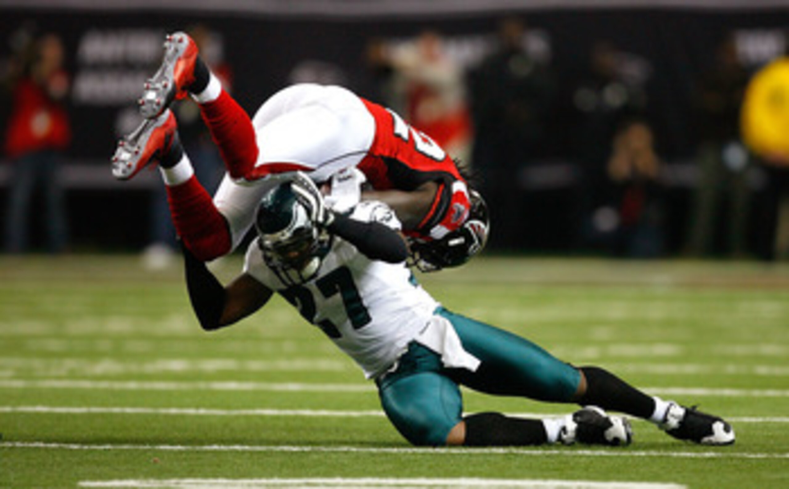 ATLANTA - DECEMBER 06:  Quintin Mikell #27 of the Philadelphia Eagles upends Jerious Norwood #32 of the Atlanta Falcons at the Georgia Dome on December 6, 2009 in Atlanta, Georgia.  (Photo by Kevin C. Cox/Getty Images)