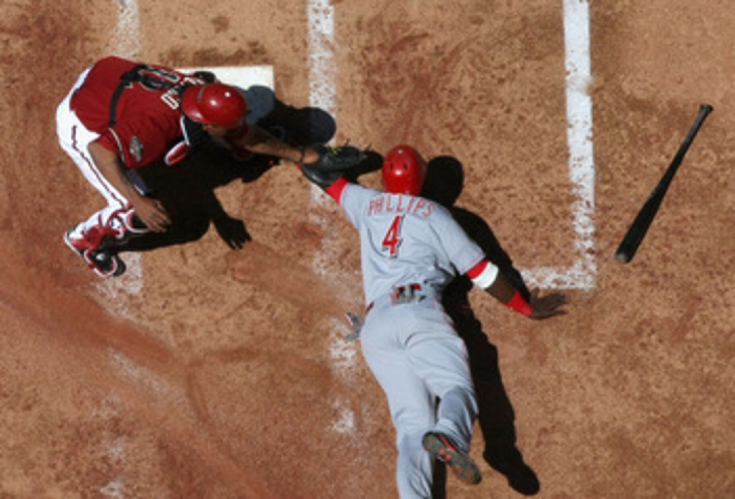 PHOENIX, AZ - APRIL 10:  Brandon Phillips #4 of the Cincinnati Reds is tagged out at home plate by catcher Henry Blanco #12 of the Arizona Diamondbacks as he attempts to score during the second inning of the Major League Baseball game at Chase Field on Ap