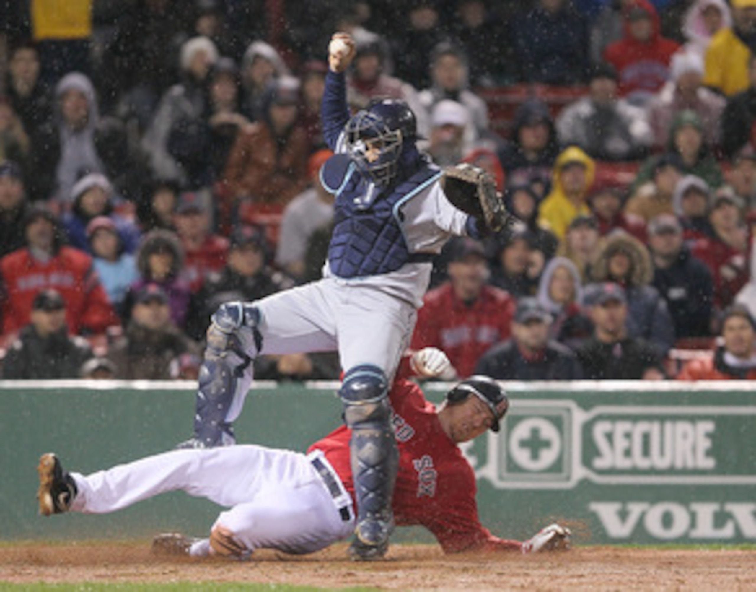 BOSTON - APRIL 17:  Dioner Navarro #30 of the Tampa Bay Rays falls as J.D. Drew #7 of the Boston Red Sox is out on a fielder's choice in the 11th inning at Fenway Park on April 17, 2010 in Boston, Massachusetts.  The contest  is a completion of the game t