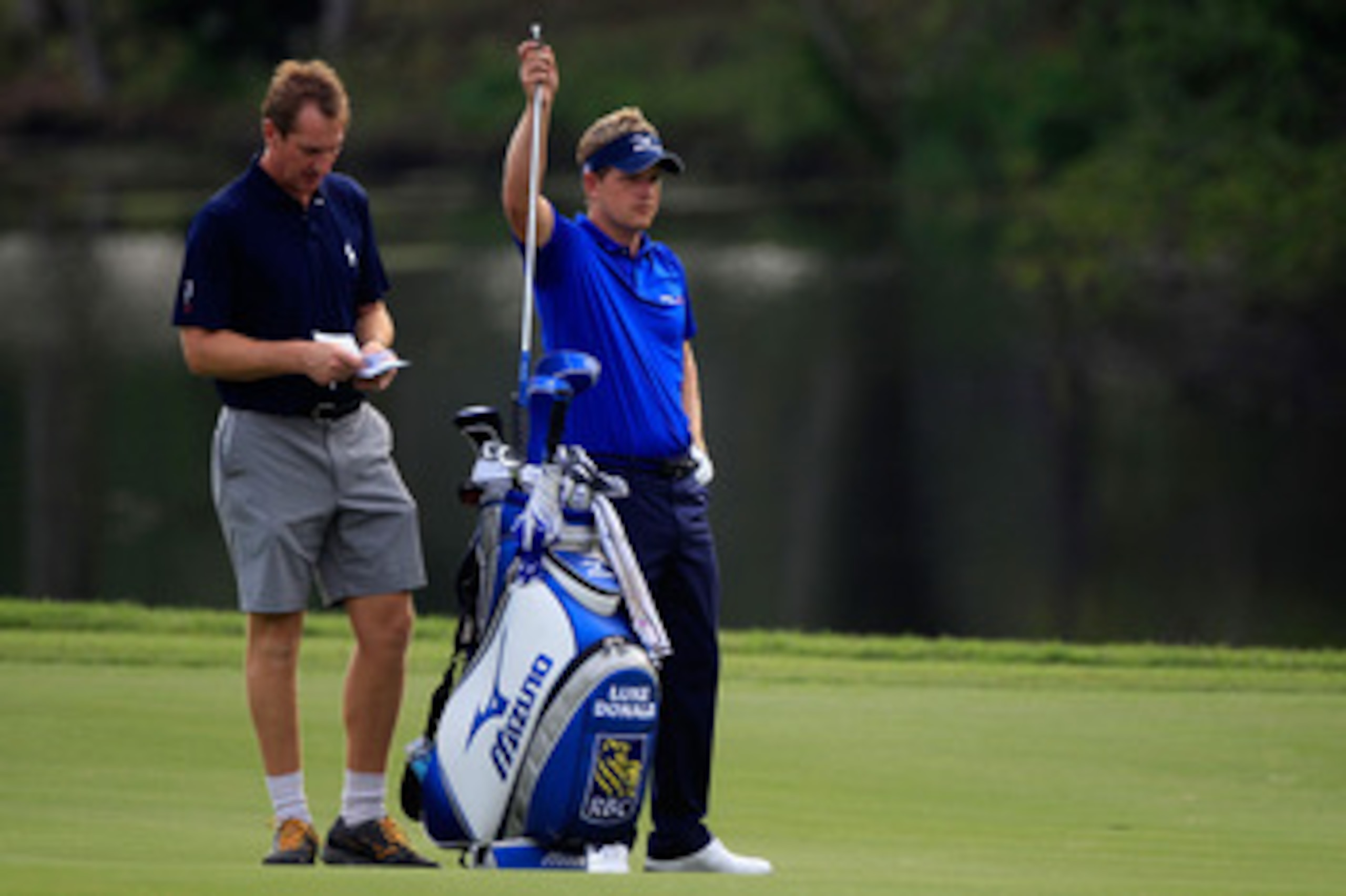 PONTE VEDRA BEACH, FL - MAY 11:  Luke Donald of England (R) pulls a club from his bag alongside caddie John McLaren (L) during a practice round prior to the start of THE PLAYERS Championship held at THE PLAYERS Stadium course at TPC Sawgrass on May 11, 20