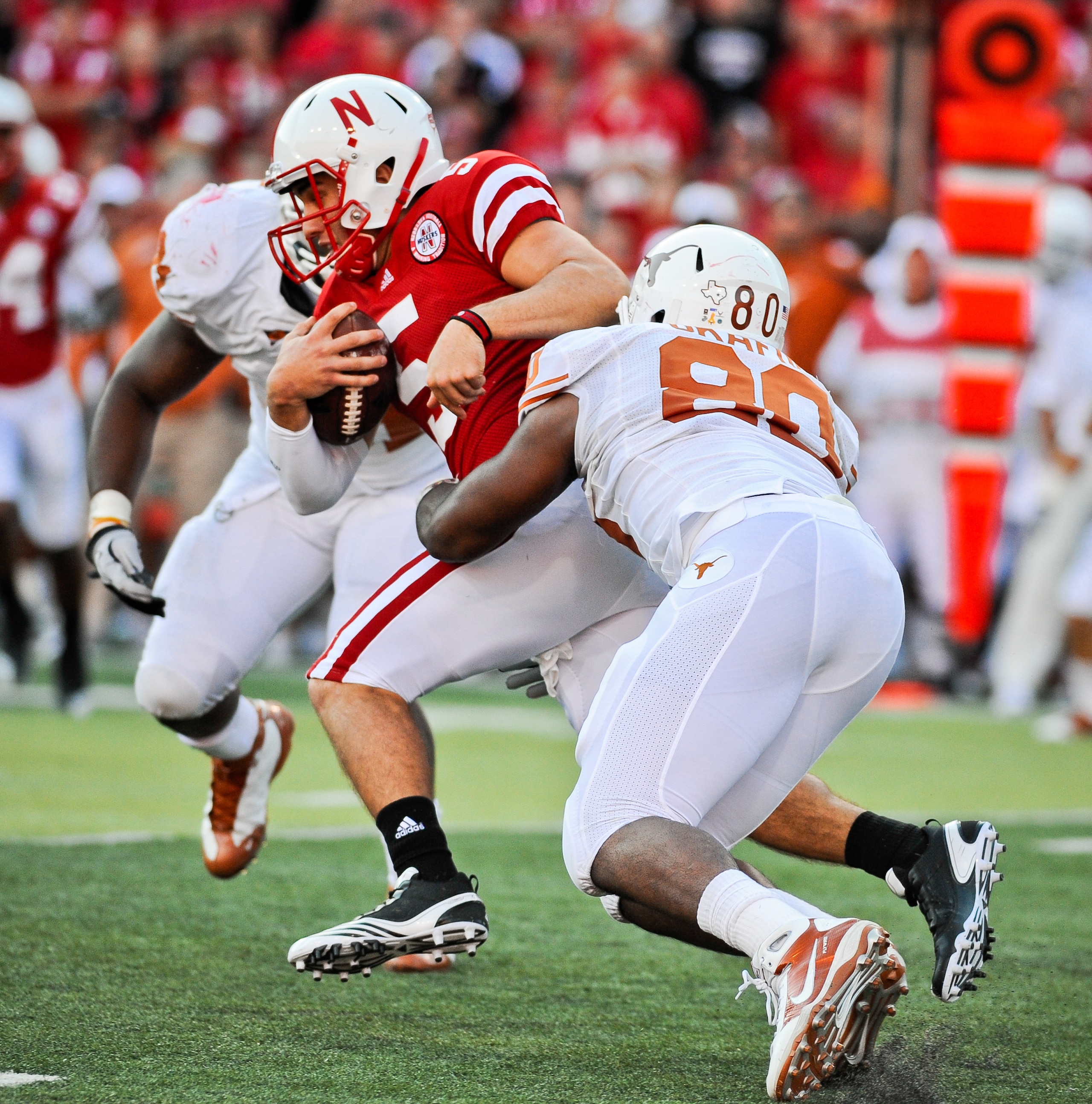 LINCOLN, NE - OCTOBER 16: Quarterback Zac Lee #5 of the Nebraska Cornhuskers gets tackled by defensive end Alex Okafor #80 of the Texas Longhorns during their game at Memorial Stadium on October 16, 2010 in Lincoln, Nebraska. Texas Defeated Nebraska 20-13