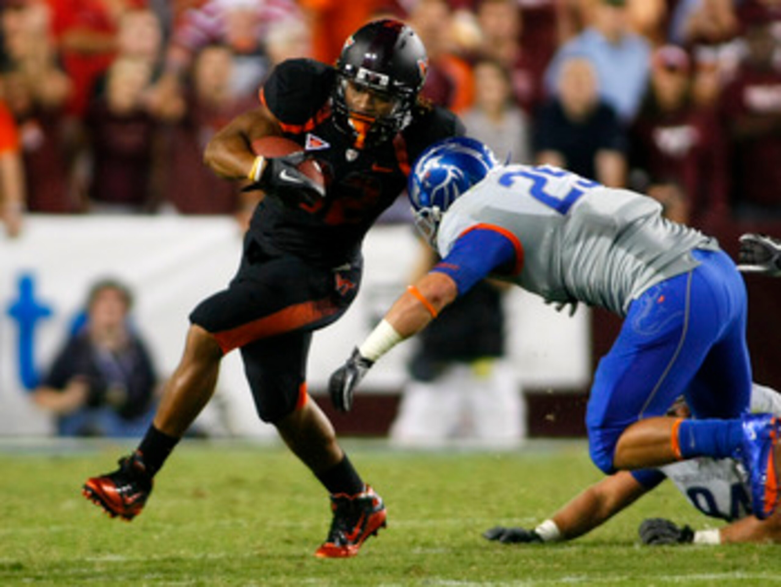LANDOVER, MD - SEPTEMBER 06:  Running back Darren Evans #32 of the Virginia Tech Hokies runs with the ball as linebacker Hunter White #25 of the Boise State Broncos defends at FedExField on September 6, 2010 in Landover, Maryland.  (Photo by Geoff Burke/G