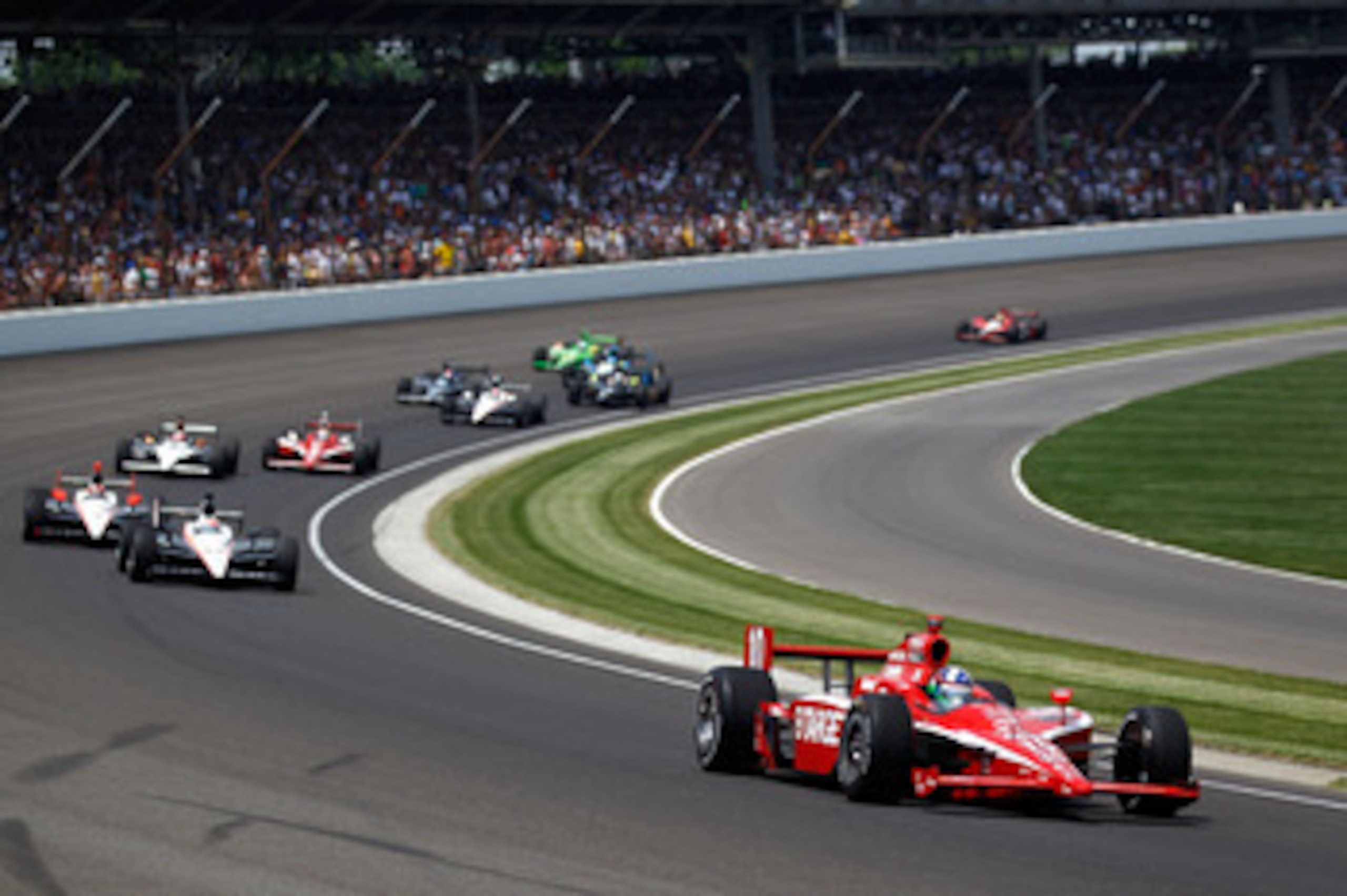 INDIANAPOLIS - MAY 30:  Dario Franchitti of Scotland, driver of the #10 Target Chip Ganassi Racing Dallara Honda, leads a pack of cars through turn one during the IZOD IndyCar Series 94th running of the Indianapolis 500 at the Indianapolis Motor Speedway