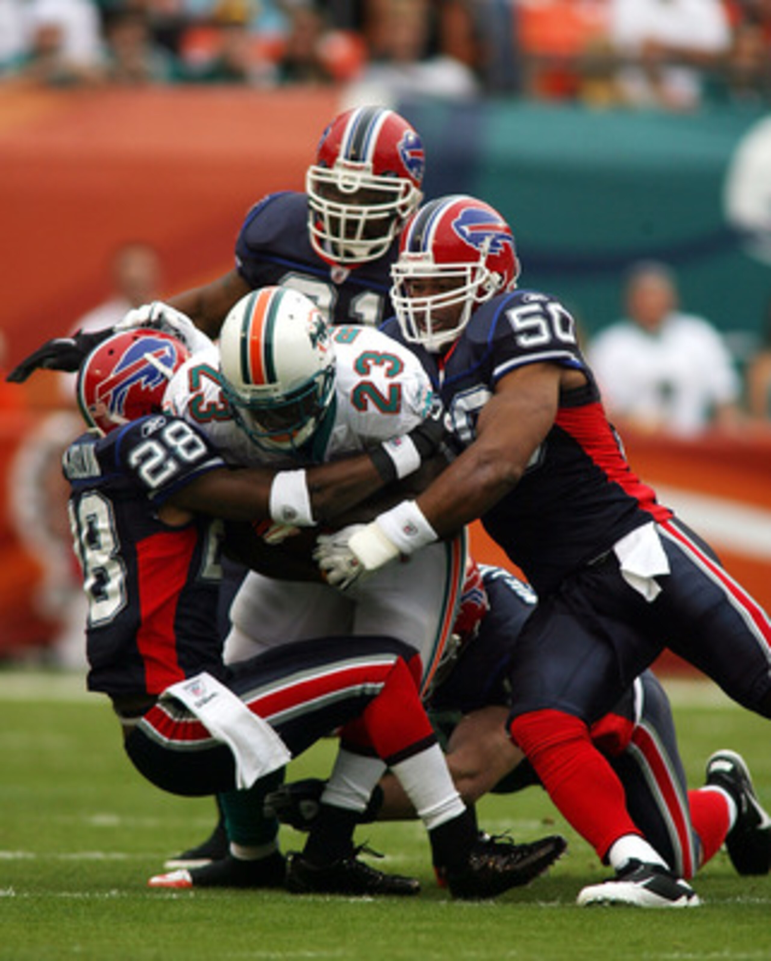 MIAMI, FL - DECEMBER 19:  Running back Ronnie Brown #23 of the Miami Dolphins is upended by cornerback Leodis McKelvin #28 and Akin Ayodele #50 of the Buffalo Bills at Sun Life Stadium on December 19, 2010 in Miami, Florida.  (Photo by Marc Serota/Getty I