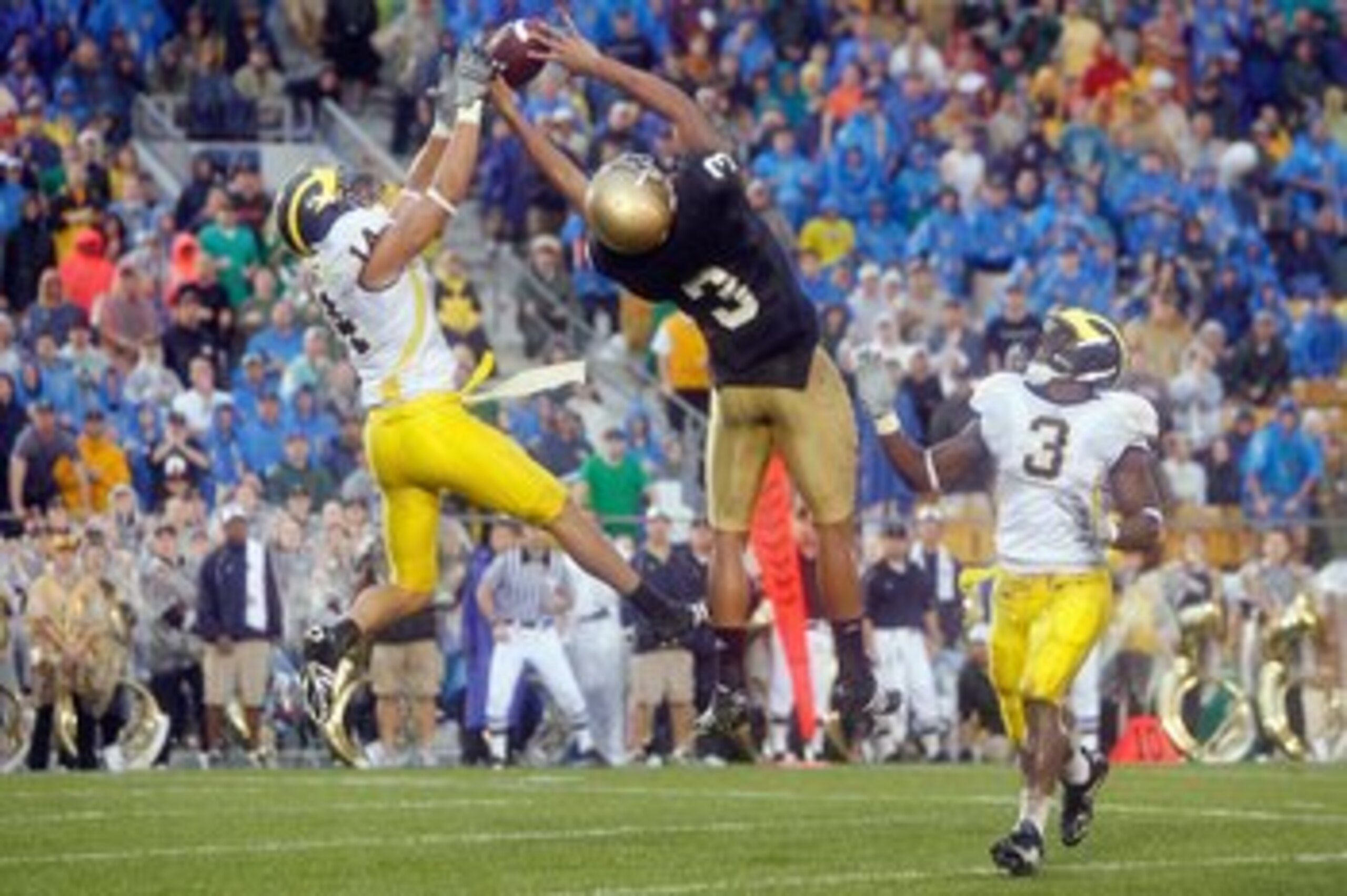 SOUTH BEND,IN - SEPTEMBER 13:  Morgan Trent #14 of the Michigan Wolverines reaches for the ball against Michael Floyd #3 of the Notre Dame Fighting Irish on September 13, 2008 at Notre Dame Stadium in South Bend, Indiana. (Photo by: Gregory Shamus/Getty I