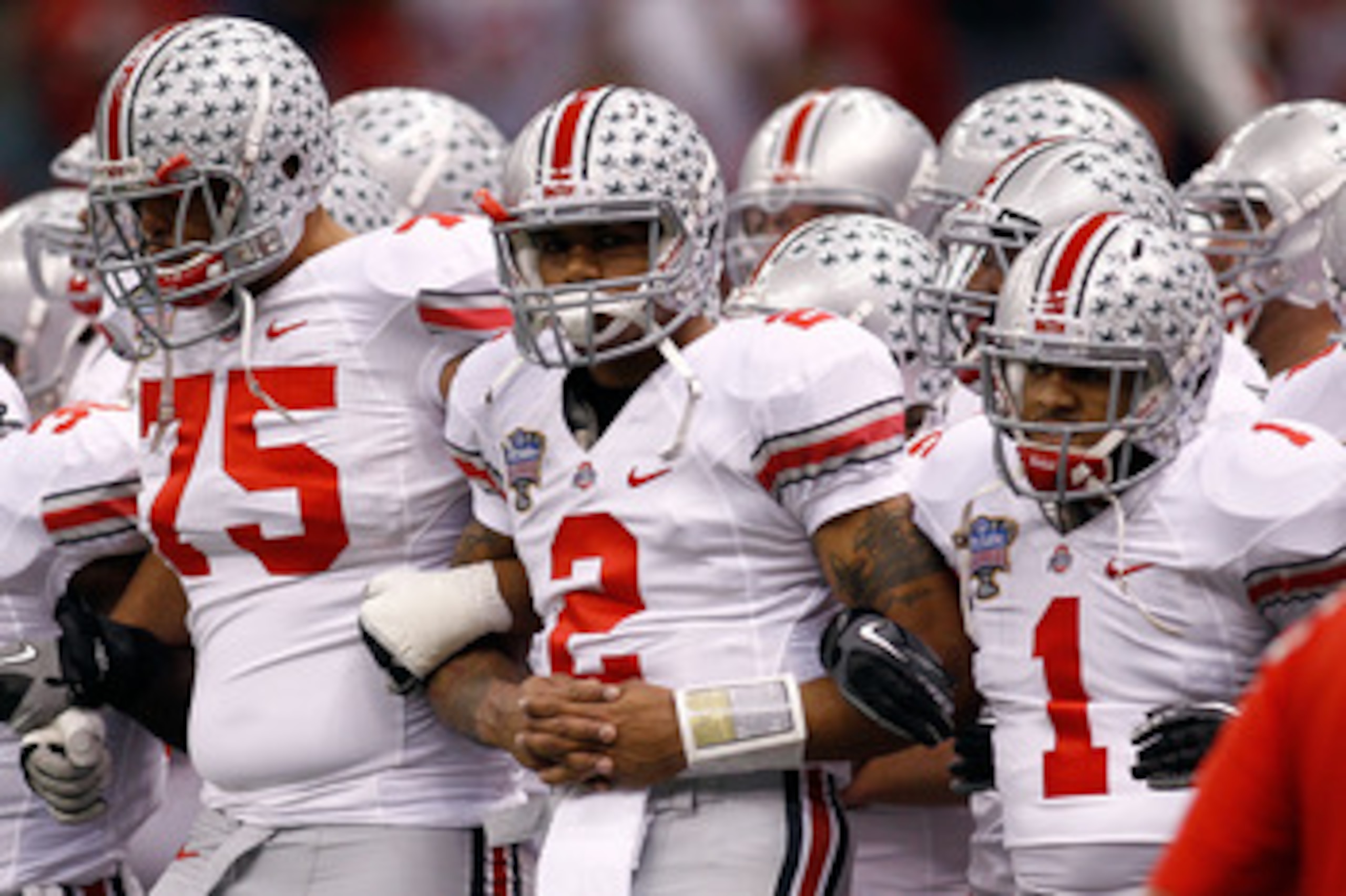 NEW ORLEANS, LA - JANUARY 04:  (R-L) Dan Herron #1, Terrelle Pryor #2 and Mike Adams #75 of the Ohio State Buckeyes gather with teammates before taking on the Arkansas Razorbacks during the Allstate Sugar Bowl at the Louisiana Superdome on January 4, 2011
