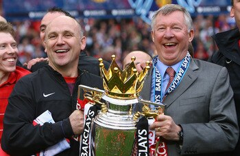 MANCHESTER, ENGLAND - MAY 16:  Manchester United Manager Sir Alex Ferguson (R) and Assistant Mike Phelan celebrate with the Barclays Premier League trophy after their side won the Premier League title at the end of the Barclays Premier League match betwee