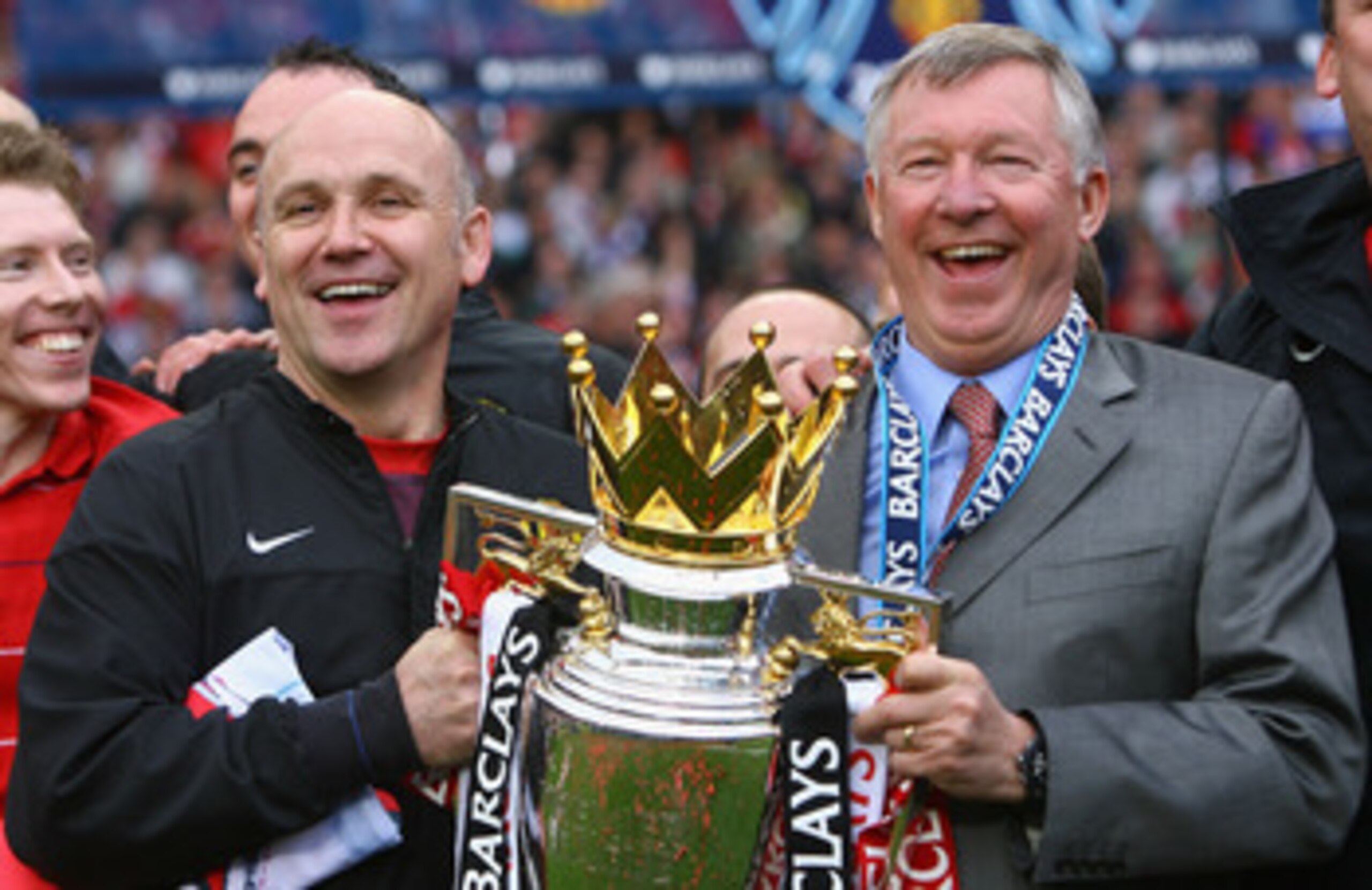 MANCHESTER, ENGLAND - MAY 16:  Manchester United Manager Sir Alex Ferguson (R) and Assistant Mike Phelan celebrate with the Barclays Premier League trophy after their side won the Premier League title at the end of the Barclays Premier League match betwee