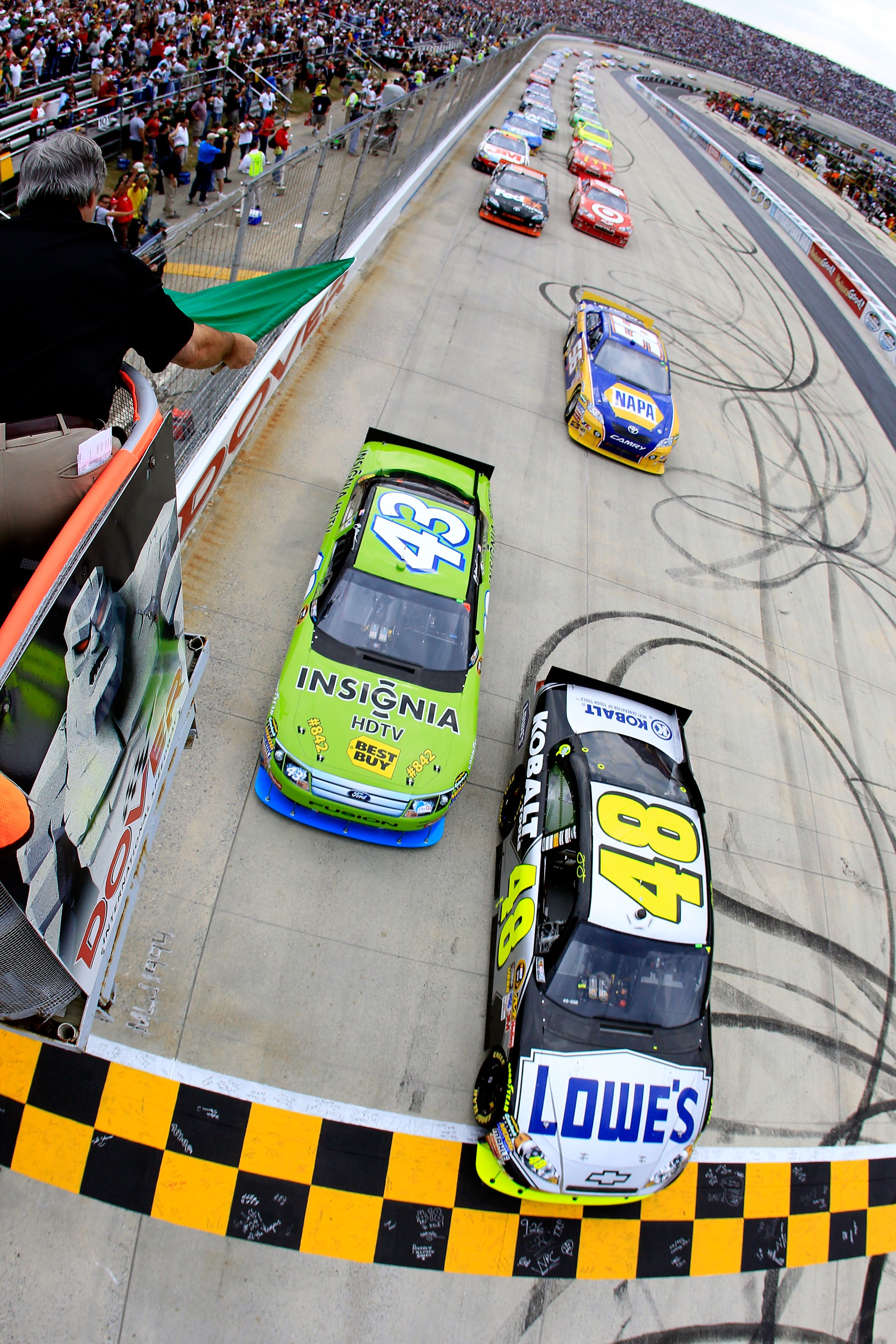 DOVER, DE - SEPTEMBER 26:  Jimmie Johnson, driver of the #48 Lowe's Chevrolet, and A.J. Allmendinger, driver of the #43 Insignia HDTV Ford, lead the field to the green flag to start the NASCAR Sprint Cup Series AAA 400 at Dover International Speedway on S