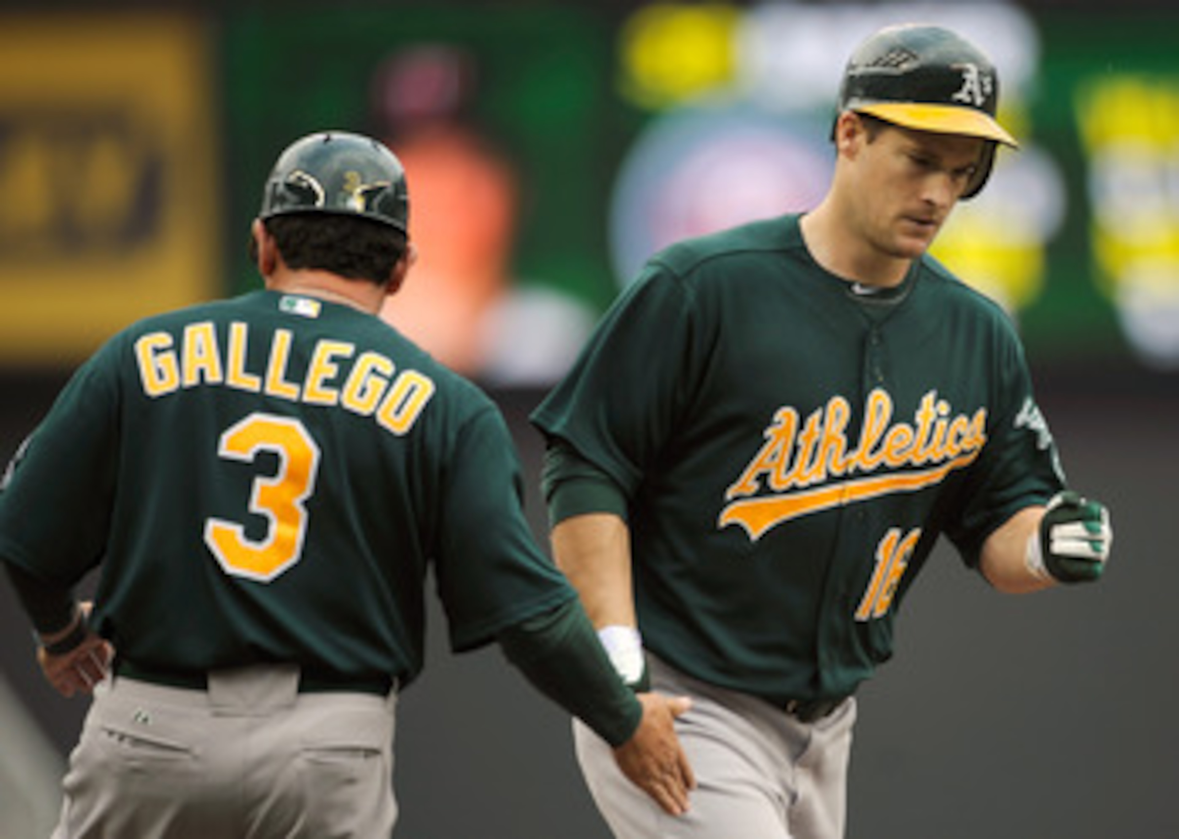 MINNEAPOLIS, MN - APRIL 10: Third base coach Mike Gallegro #3 of the Oakland Athletics congratulates Josh Willingham #16 as he rounds the bases following a solo home run off of Scott Baker #30 of the Minnesota Twins during the fourth inning of their game 