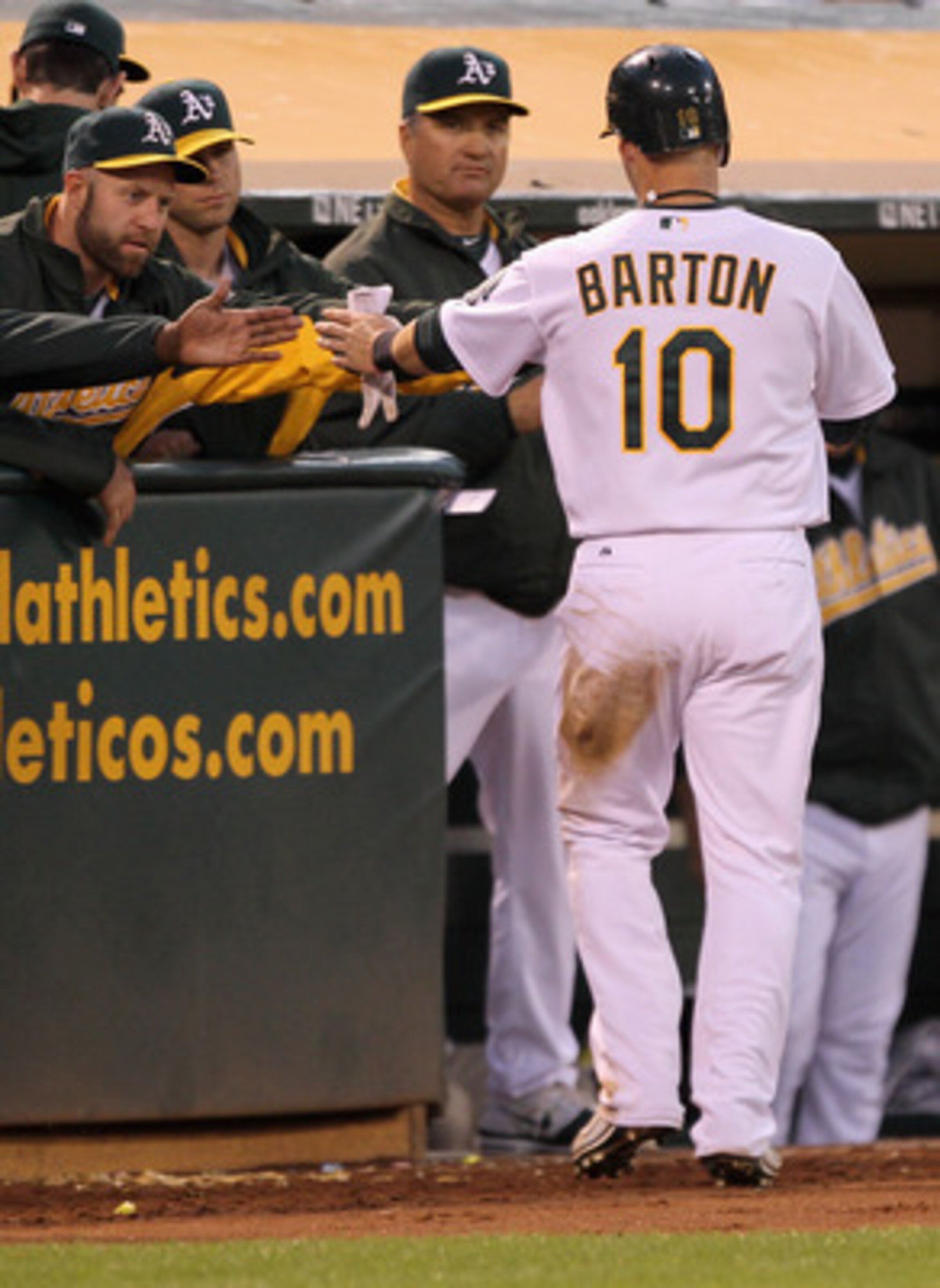 OAKLAND, CA - MAY 03:  Daric Barton #10 of the Oakland Athletics is congratulated by teammates after he scored on a ground out by Kurt Suzuki #8 of the Oakland Athletics in the fourth inning of their game against the Cleveland Indians at Oakland-Alameda C