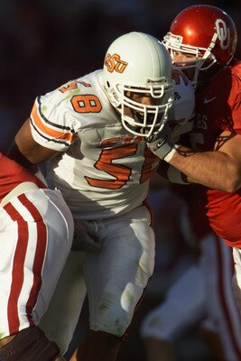 NORMAN, OK - NOVEMBER 24:  Defensive Tackle Kevin Williams #58 of the Oklahoma State Cowboys looks to be having fun as he breaks past offensive lineman Mike Skinner #75 of the Oklahoma Sooners in the second quarter of the game on November 24, 2001 at Owen
