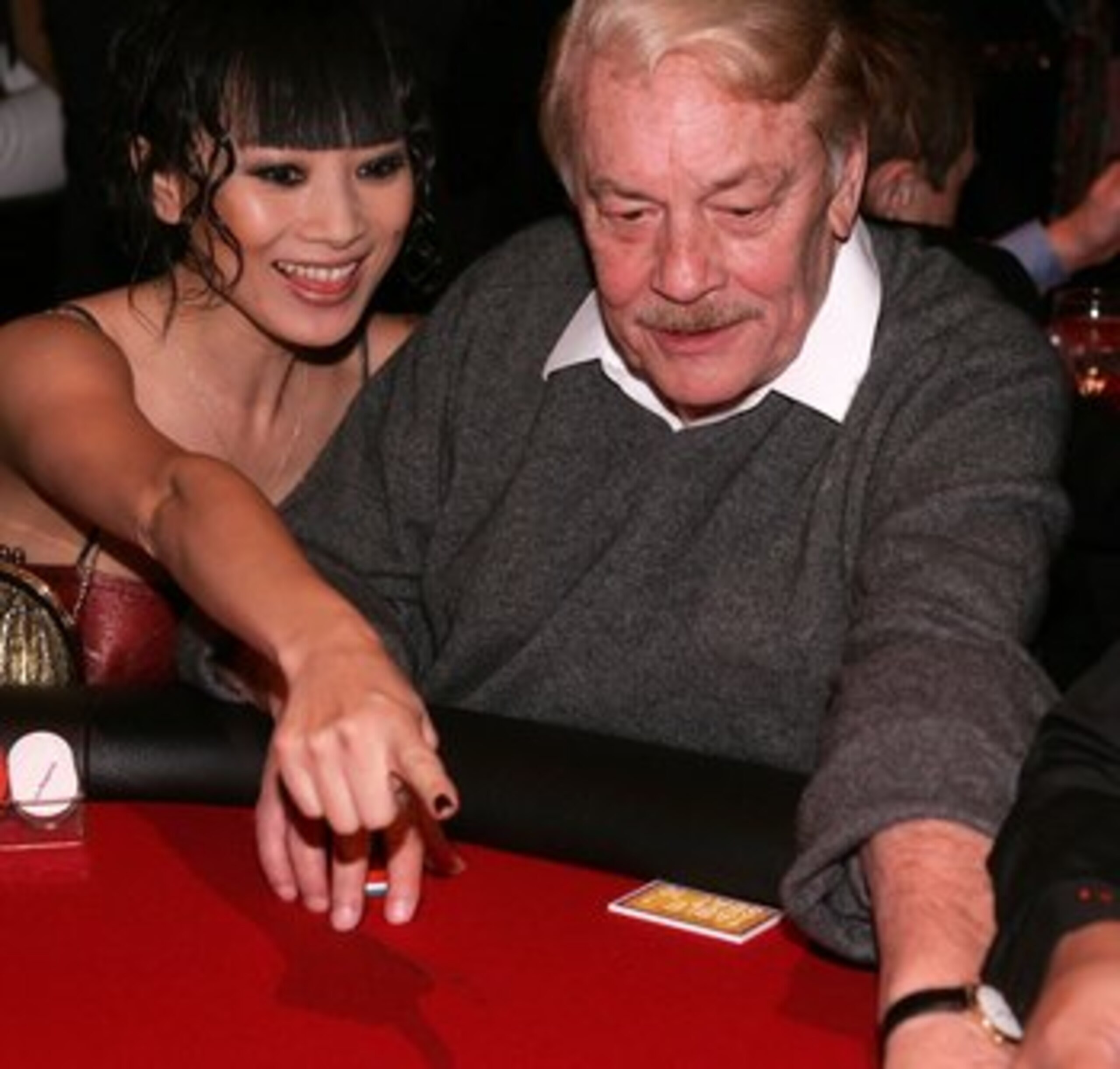 SANTA MONICA, CA - APRIL 12:  Actress Bai Ling and Dr. Jerry Buss play poker at the Los Angeles  Lakers 3rd annual Mirage Las Vegas Casino Night and Bodog Celebrity Poker Invitational benefiting Los Angeles Lakers Youth Foundation at Barker Hangar on Apri