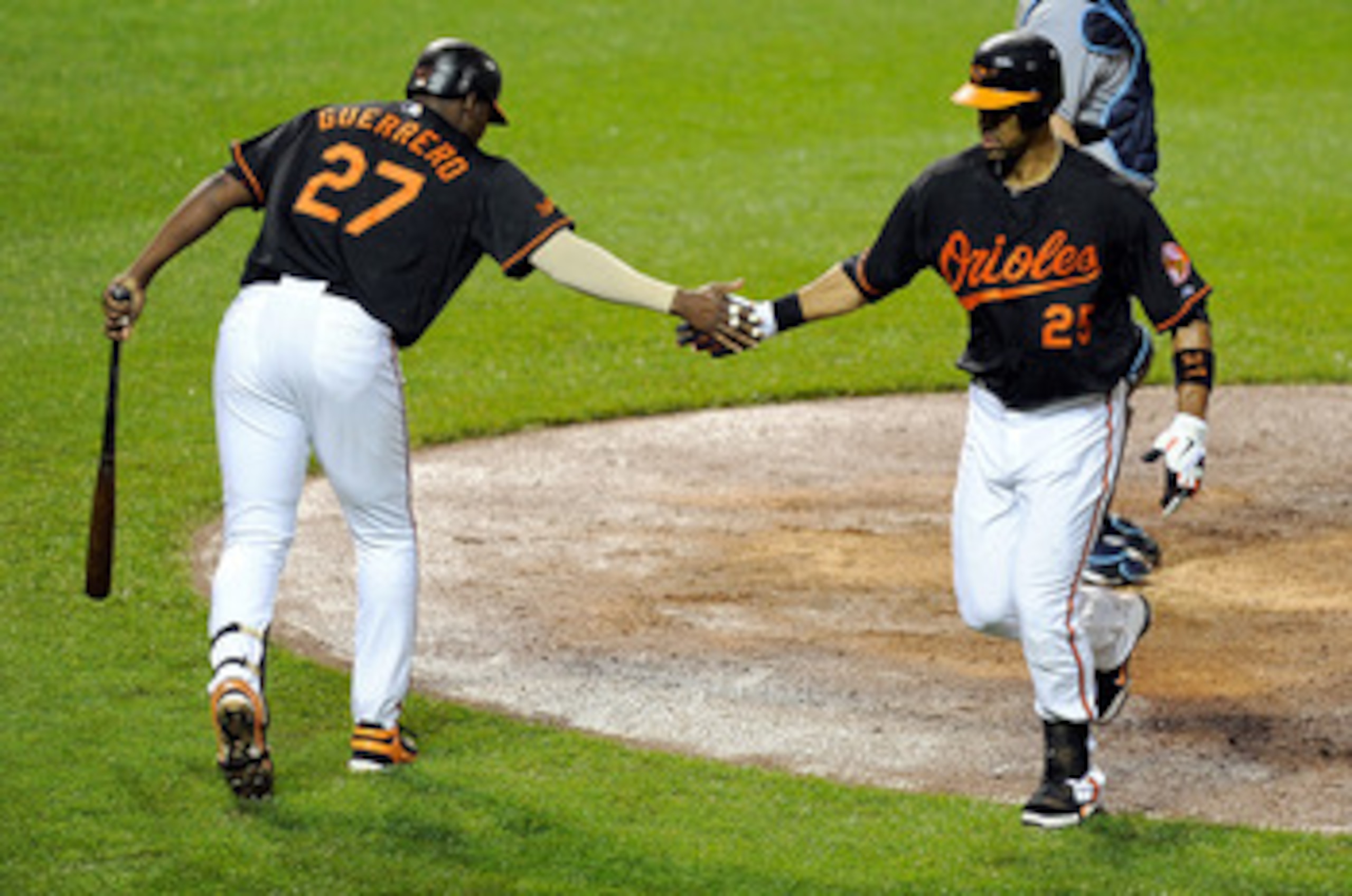 BALTIMORE, MD - MAY 06: Derrek Lee #25 of the Baltimore Orioles celebrates with Vladimir Guerrero #27 after hitting a home run in the sixth inning against the Tampa Bay Rays at Oriole Park at Camden Yards on May 6, 2011 in Baltimore, Maryland.  (Photo by