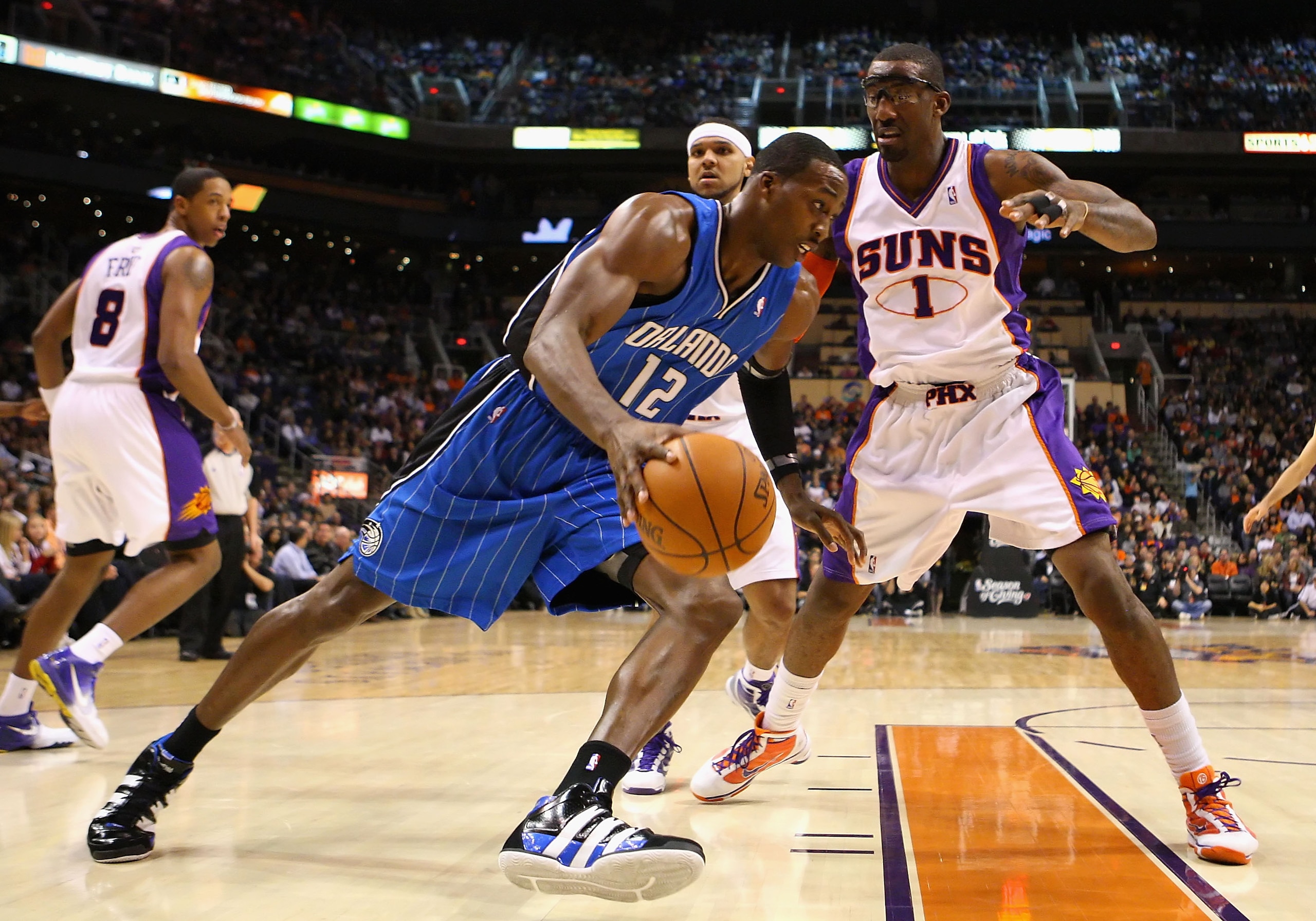 PHOENIX - DECEMBER 11: Dwight Howard #12 of the Orlando Magic drives the ball against Amar'e Stoudemire #1 of the Phoenix Suns during the NBA game at US Airways Center on December 11, 2009 in Phoenix, Arizona. NOTE TO USER: User expressly acknowledges an PHOENIX - DECEMBER 11: Dwight Howard #12 of the Orlando Magic drives the ball against Amar'e Stoudemire #1 of the Phoenix Suns during the NBA game at US Airways Center on December 11, 2009 in Phoenix, Arizona. NOTE TO USER: User expressly acknowledges an