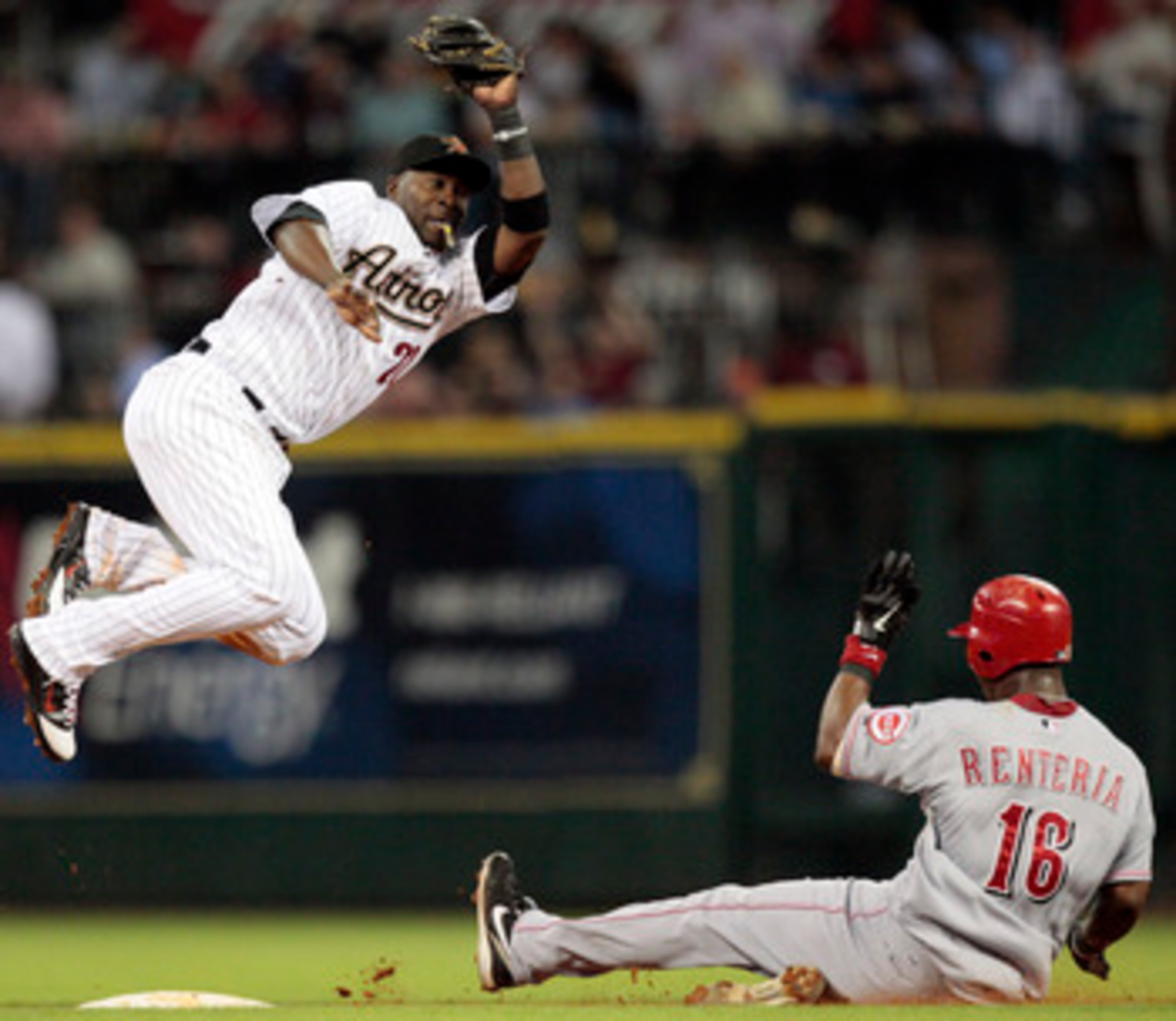 HOUSTON - MAY 09:  Second baseman Bill Hall #22 of the Houston Astros leaps to catch a throw from catcher J.R. Towles as Edgar Renteria #16 of the Cincinnati Reds slides in safely at Minute Maid Park on May 9, 2011 in Houston, Texas.  (Photo by Bob Levey/
