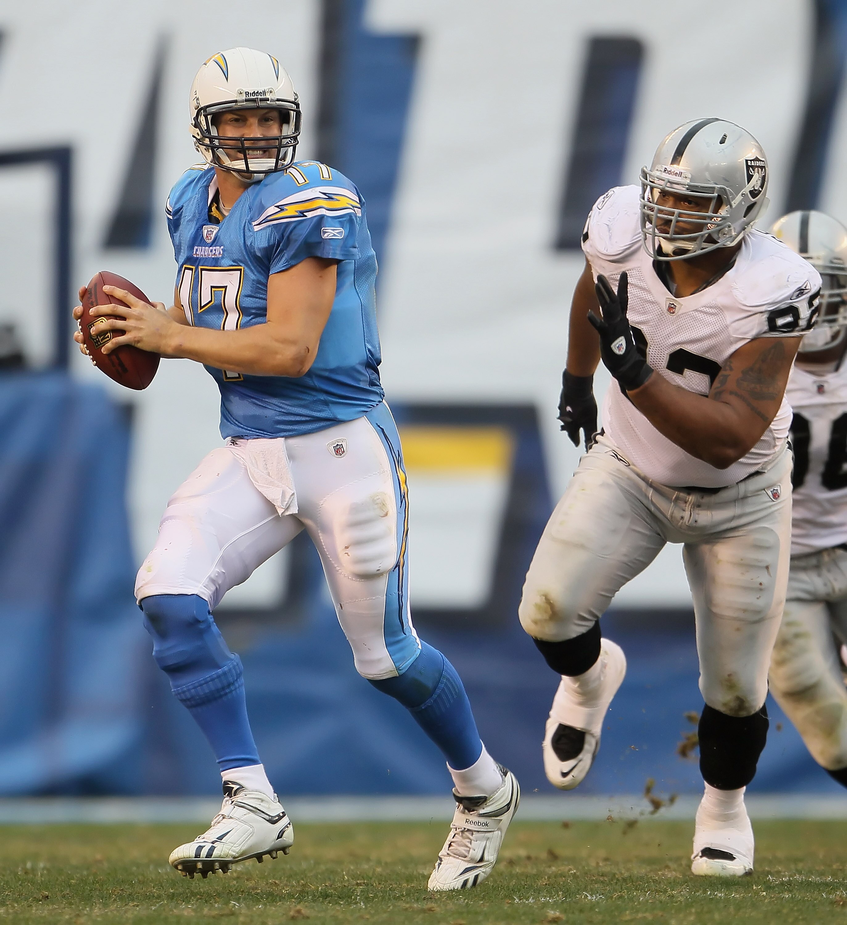 SAN DIEGO - DECEMBER 05:  Quarterback Philip Rivers #17 of the San Diego Chargers is chased out of the pocket by Richard Seymour #92 of the Oakland Raiders in the third quarter at Qualcomm Stadium on December 5, 2010 in San Diego, California. The Raiders