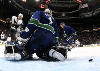 VANCOUVER, CANADA - OCTOBER 13:   Patrick Marleau #12 of the San Jose Sharks shoots the puck past Roberto Luongo #1 of the Vancouver Canucks as Mattias Ohlund #2 of the Canucks looks on during their game at General Motors Place on October 13, 2006 in Vanc