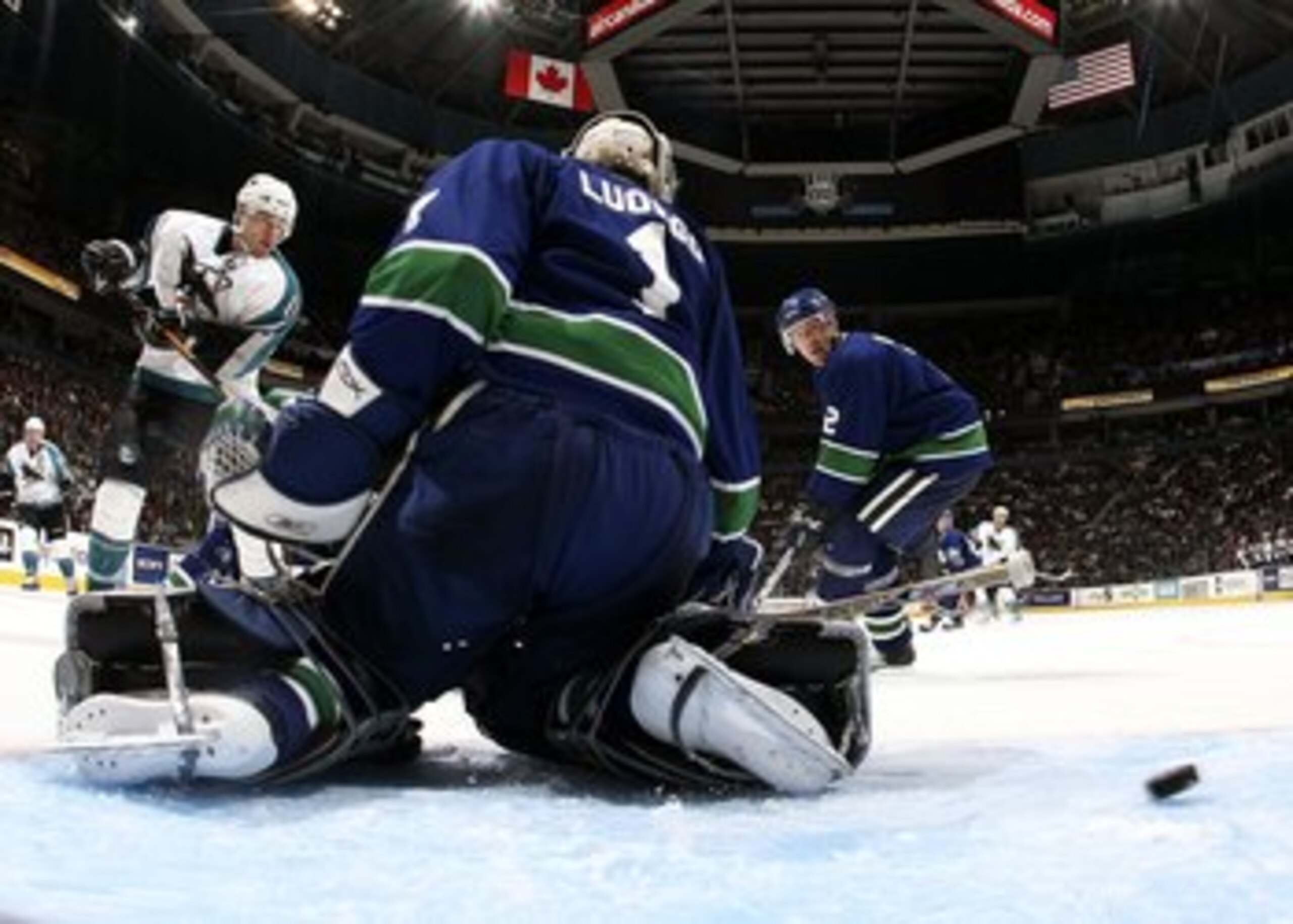 VANCOUVER, CANADA - OCTOBER 13:   Patrick Marleau #12 of the San Jose Sharks shoots the puck past Roberto Luongo #1 of the Vancouver Canucks as Mattias Ohlund #2 of the Canucks looks on during their game at General Motors Place on October 13, 2006 in Vanc