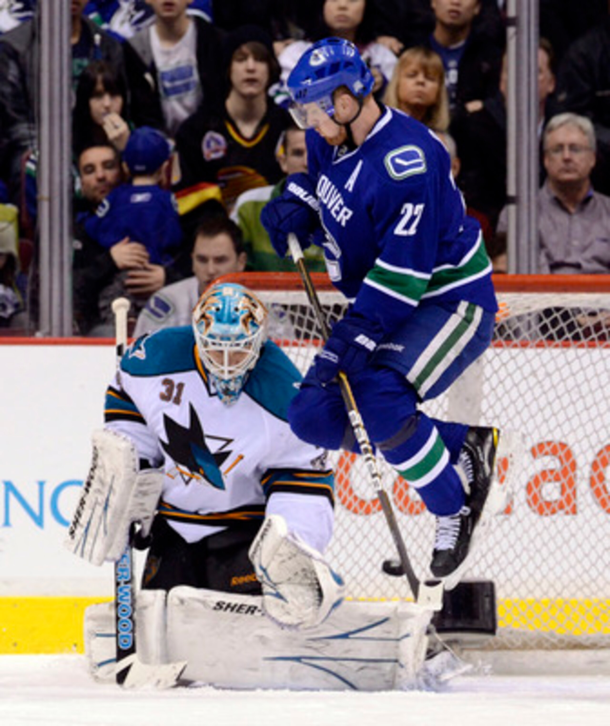 VANCOUVER, CANADA - JANUARY 20: Daniel Sedin #22 of the Vancouver Canucks jumps out of the way as goalie Antti Niemi #31 of the San Jose Sharks makes a save during the first period in NHL action on January 20, 2011 at Rogers Arena in Vancouver, BC, Canada