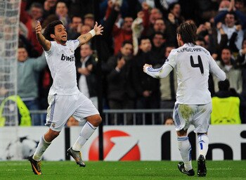MADRID, SPAIN - MARCH 16:  Marcelo Vieira of Real Madrid celebrates with Sergio Ramos after scoring Real's opening goal during the UEFA Champions League round of 16 second leg match between Real Madrid and Lyon at Estadio Santiago Bernabeu on March 16, 20