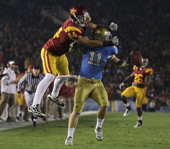 PASADENA, CA - DECEMBER 04:  Sean Westgate #11 of the UCLA Bruins breaks up a pass intended for Jordan Cameron #84 of the USC Trojans during the first half at the Rose Bowl on December 4, 2010 in Pasadena, California. USC defeated UCLA 28-14.  (Photo by J
