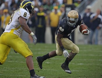 SOUTH BEND, IN - SEPTEMBER 11: Armando Allen, Jr. #5 of the Notre Dame Fighting Irish runs as Jonas Mouton #8 of the Michigan Wolverines closes in at Notre Dame Stadium on September 11, 2010 in South Bend, Indiana. Michigan defeated Notre Dame 28-24. (Pho