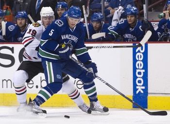 VANCOUVER, CANADA - APRIL 26: Christian Ehrhoff #5 of the Vancouver Canucks and Jonathan Toews #19 of the Chicago Blackhawks battle for the puck during the first period in Game Seven of the Western Conference Quarterfinals during the 2011 NHL Stanley Cup 