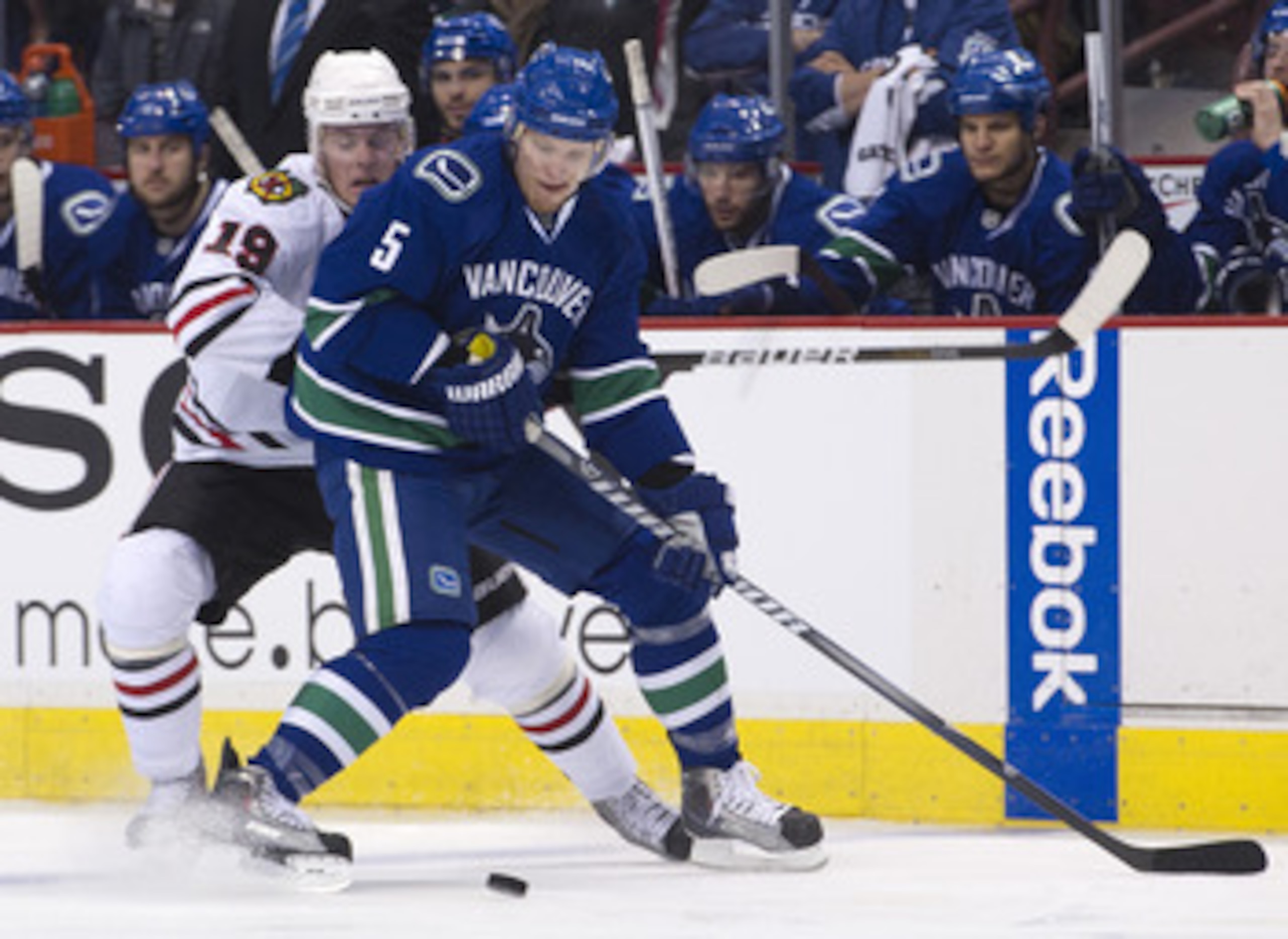 VANCOUVER, CANADA - APRIL 26: Christian Ehrhoff #5 of the Vancouver Canucks and Jonathan Toews #19 of the Chicago Blackhawks battle for the puck during the first period in Game Seven of the Western Conference Quarterfinals during the 2011 NHL Stanley Cup 