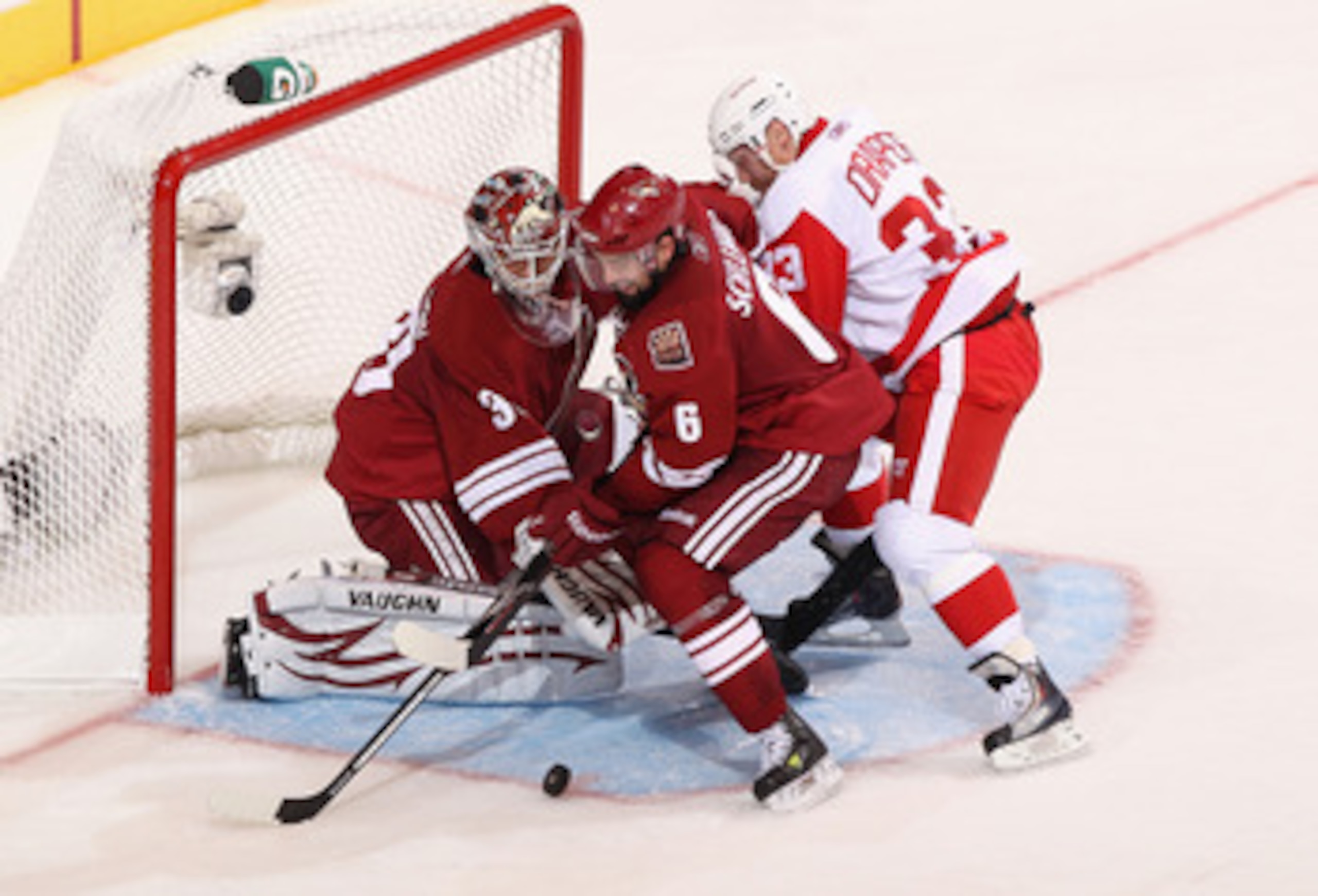 GLENDALE, AZ - APRIL 20:  David Schlemko #6 of the Phoenix Coyotes attempts to clear the puck from goaltender Ilya Bryzgalov #30 as Kris Draper #33 of the Detroit Red Wings skates in Game Four of the Western Conference Quarterfinals during the 2011 NHL St