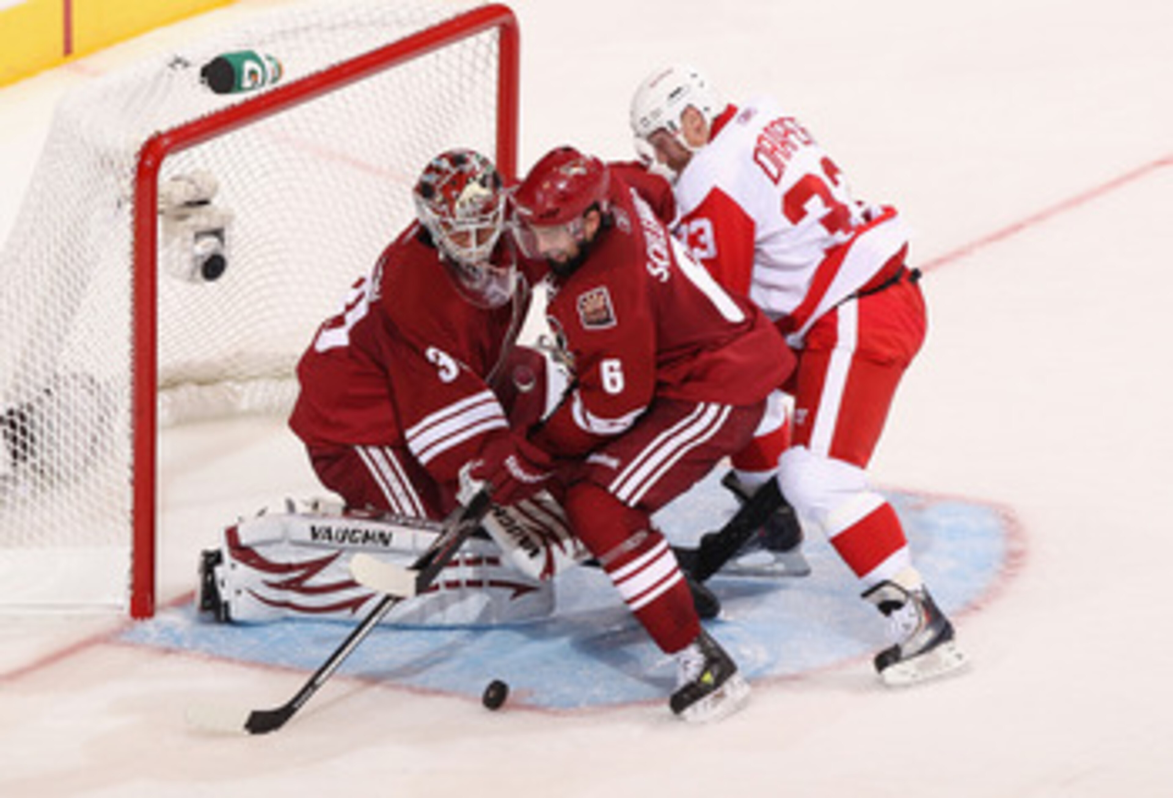 GLENDALE, AZ - APRIL 20:  David Schlemko #6 of the Phoenix Coyotes attempts to clear the puck from goaltender Ilya Bryzgalov #30 as Kris Draper #33 of the Detroit Red Wings skates in Game Four of the Western Conference Quarterfinals during the 2011 NHL St