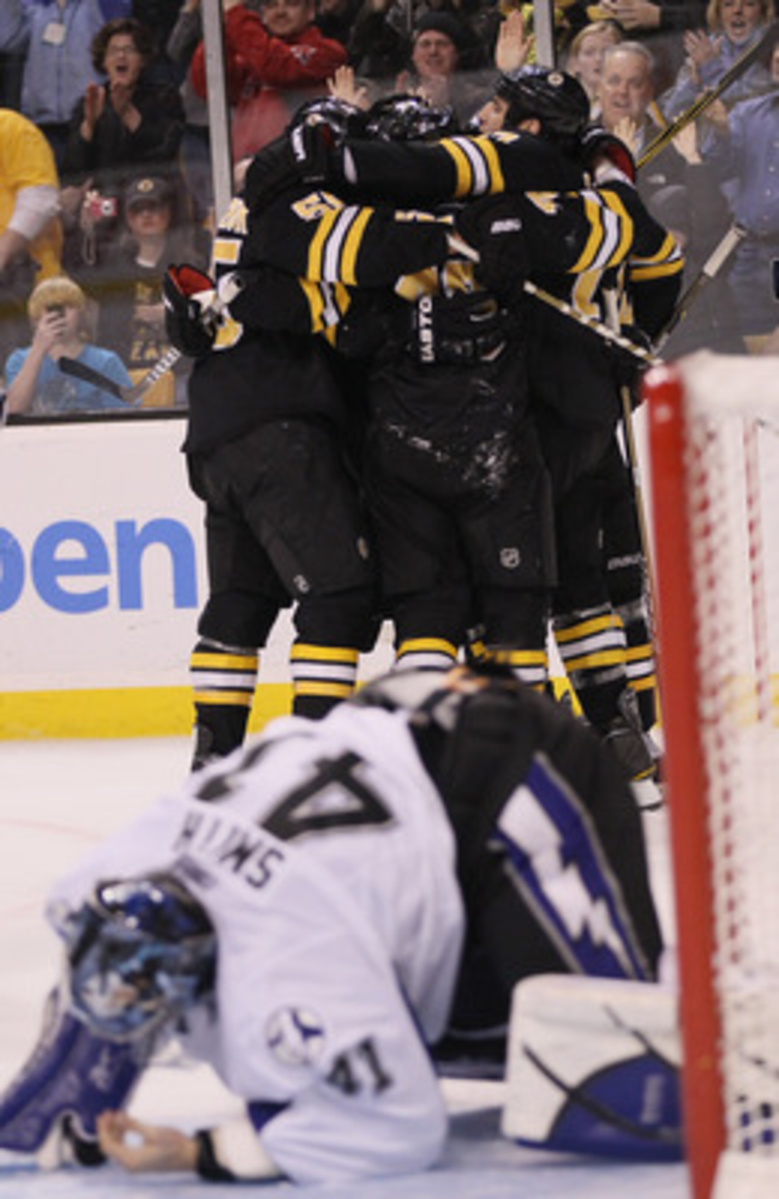 BOSTON, MA - MARCH 03:  Milan Lucic #17 of the Boston Bruins is congratulated by teammates after he scored the game winning goal as Mike Smith #41 of the Tampa Bay Lightning gets up off the ice on March 3, 2011 at the TD Garden in Boston, Massachusetts. T