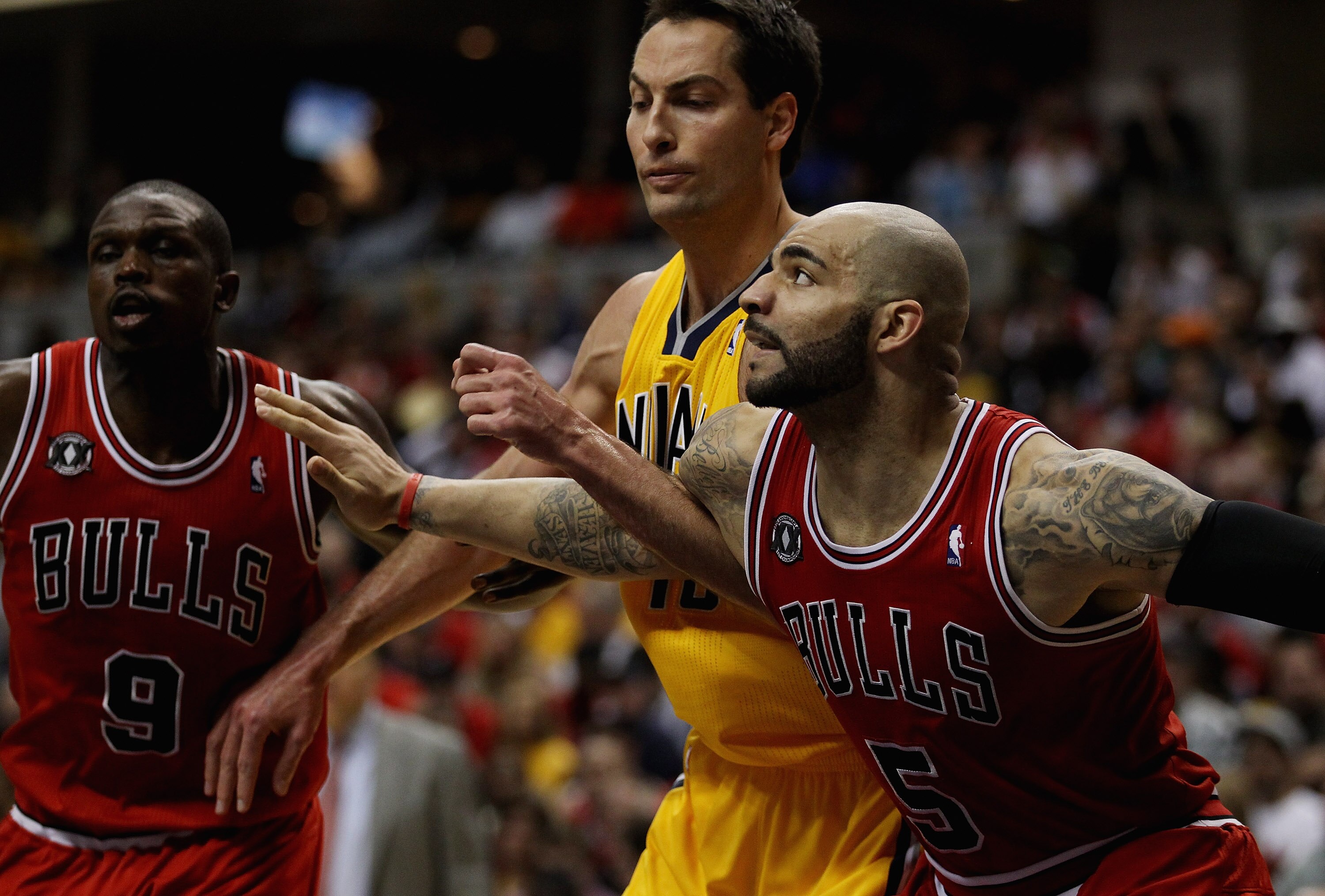 INDIANAPOLIS, IN - APRIL 23: Carlos Boozer #5 and Loul Deng #9 of the Chicago Bulls position themselves against Jeff Foster #10 of the Indiana Pacers during a free-throw in Game Four of the Eastern Conference Quarterfinals in the 2011 NBA Playoffs at Cons