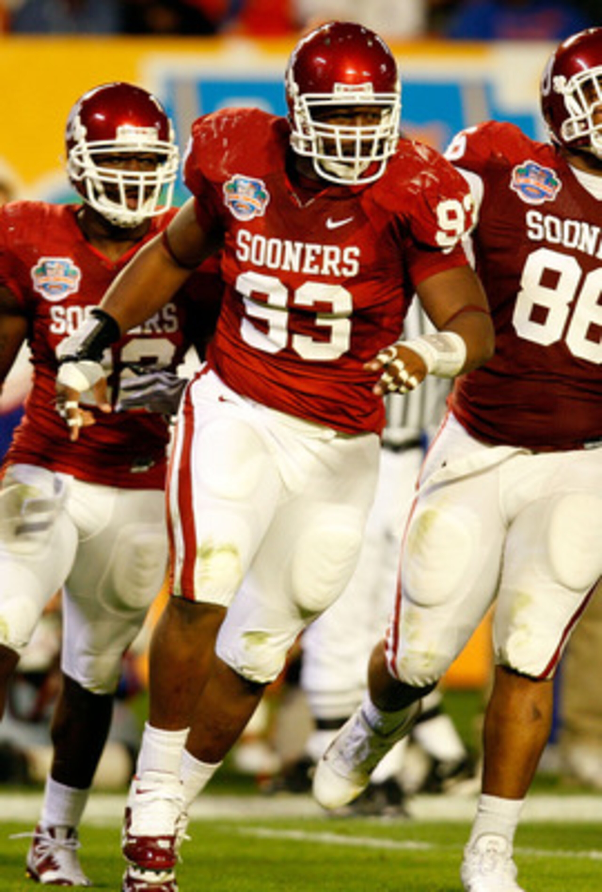 MIAMI - JANUARY 08:  (L-R) Keenan Calhoun #22, Gerald McCoy #93 and Adrian Taylor #86 of the Oklahoma Sooners celebrate a defensive stop against the Florida Gators during the FedEx BCS National Championship game at Dolphin Stadium on January 8, 2009 in Mi