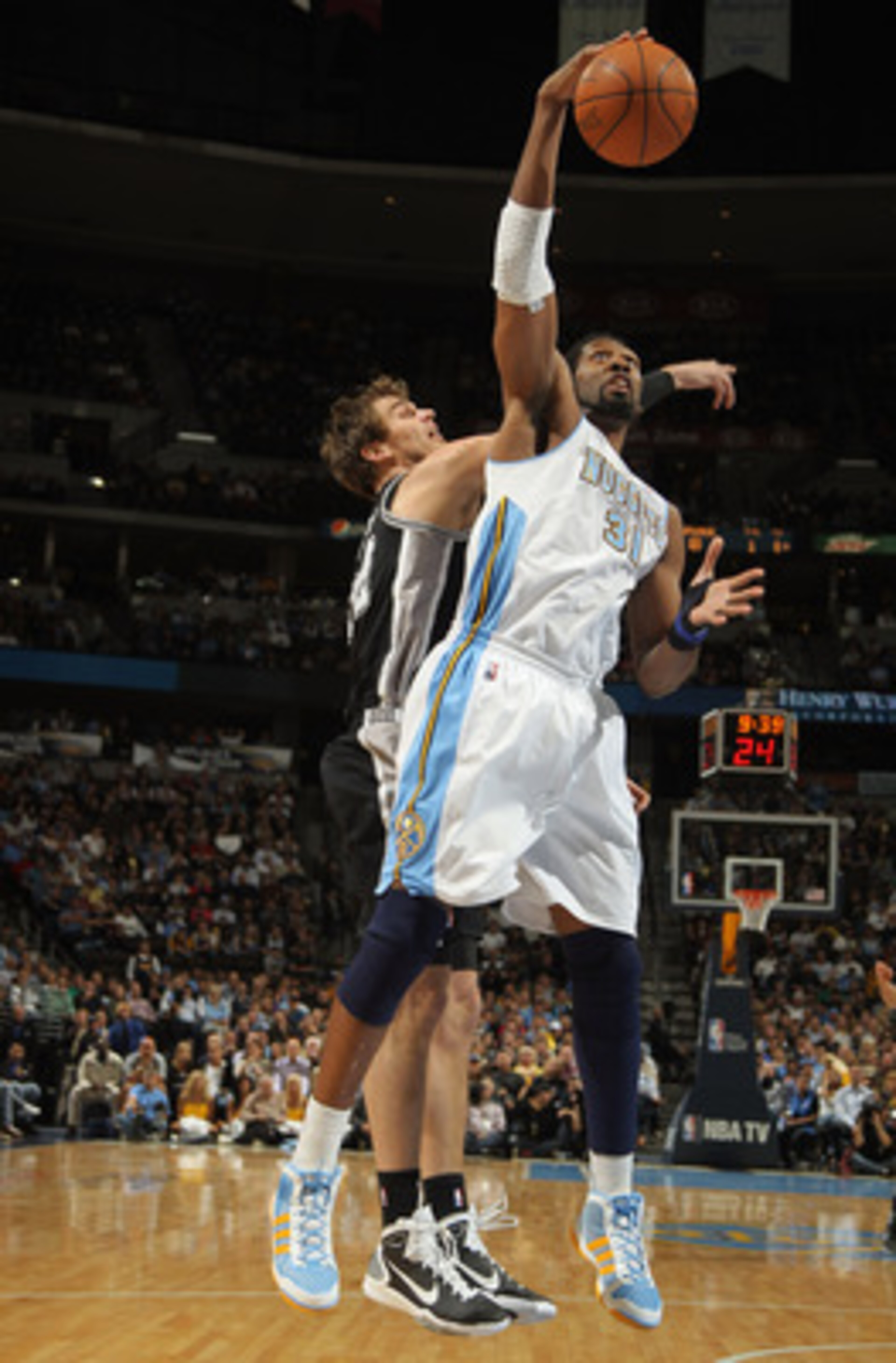 DENVER, CO - MARCH 23: Nene #31 of the Denver Nuggets grabs a rebound away from Tiago Splitter #22 at the Pepsi Center on March 23, 2011 in Denver, Colorado. The Nuggets defeated the Spurs 115-112. NOTE TO USER: User expressly acknowledges and agrees tha DENVER, CO - MARCH 23: Nene #31 of the Denver Nuggets grabs a rebound away from Tiago Splitter #22 at the Pepsi Center on March 23, 2011 in Denver, Colorado. The Nuggets defeated the Spurs 115-112. NOTE TO USER: User expressly acknowledges and agrees tha
