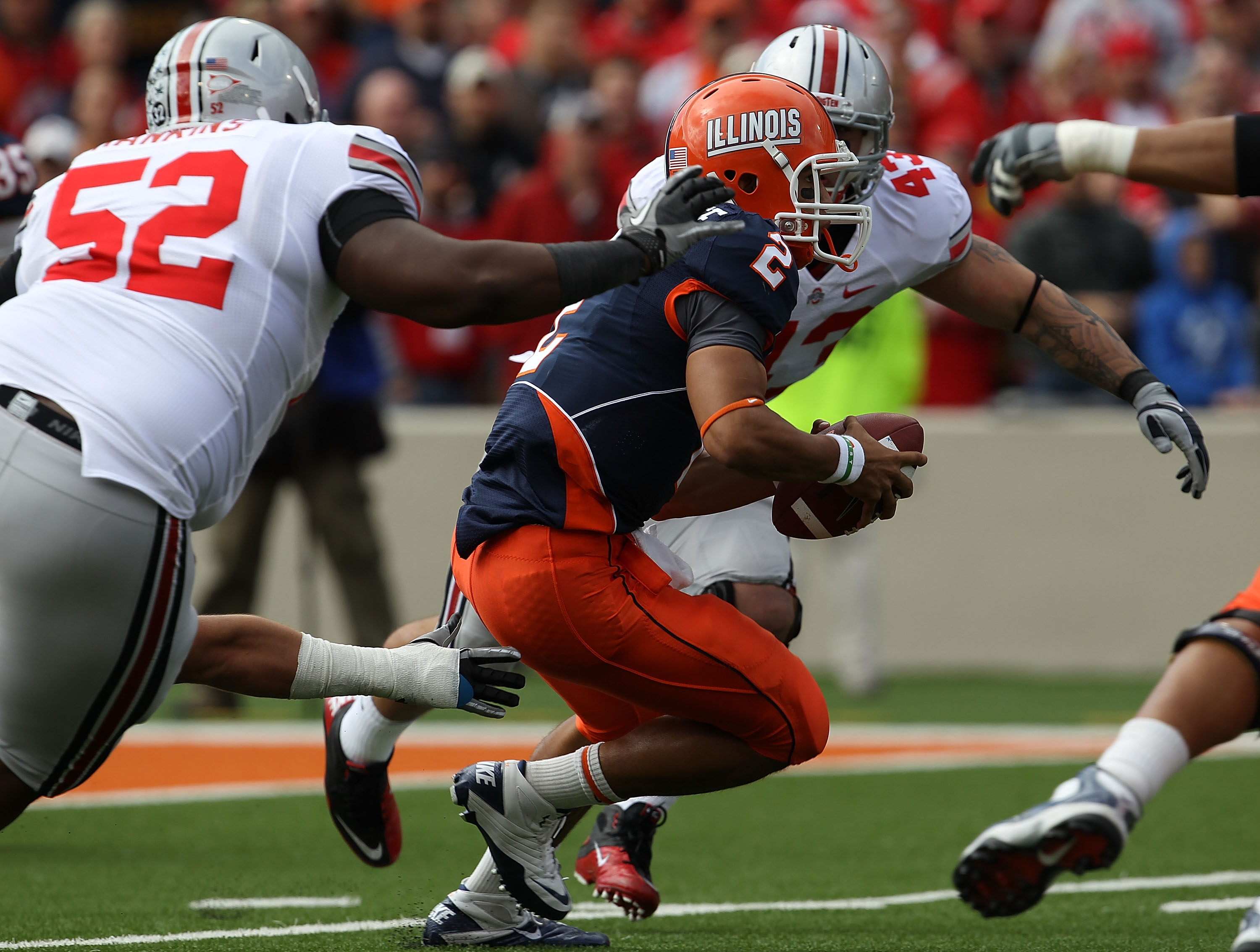 CHAMPAIGN, IL - OCTOBER 02: Nathan Scheelhaase #2 of the Illinois Fighting Illini tries to avoid Johnathan Hankins #52 and Nathan Williams #43  of the Ohio State Buckeyes at Memorial Stadium on October 2, 2010 in Champaign, Illinois. Ohio State defeated I