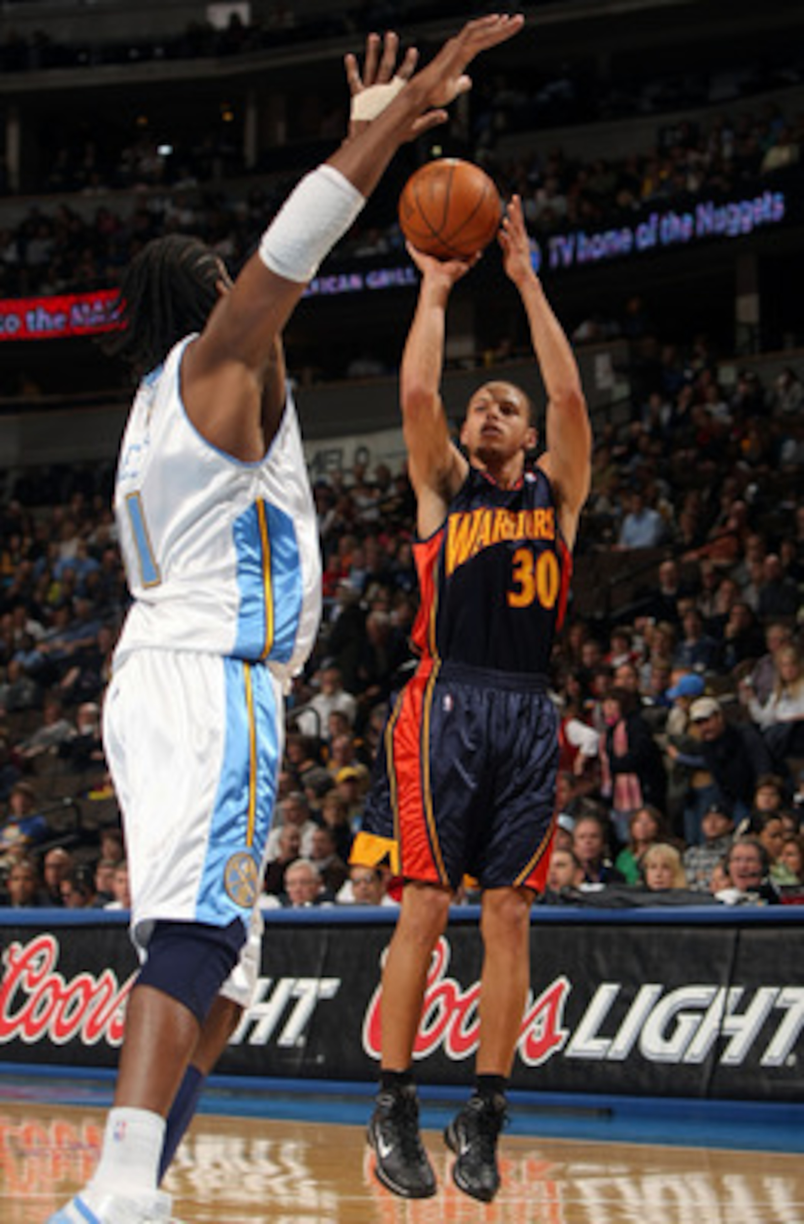 DENVER - JANUARY 05:  Stephen Curry #30 of the Golden State Warriors gets off a shot against Nene #31 of the Denver Nuggets at the Pepsi Center on January 5, 2010 in Denver, Colorado. NOTE TO USER: User expressly acknowledges and agrees that, by downloadi