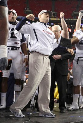 ATLANTA - DECEMBER 4:  Head coach Gene Chizik of the Auburn Tigers celebrates on the podium after the 2010 SEC Championship against the South Carolina Gamecocks at Georgia Dome on December 4, 2010 in Atlanta, Georgia. The Tigers beat the Gamecocks 56-17.