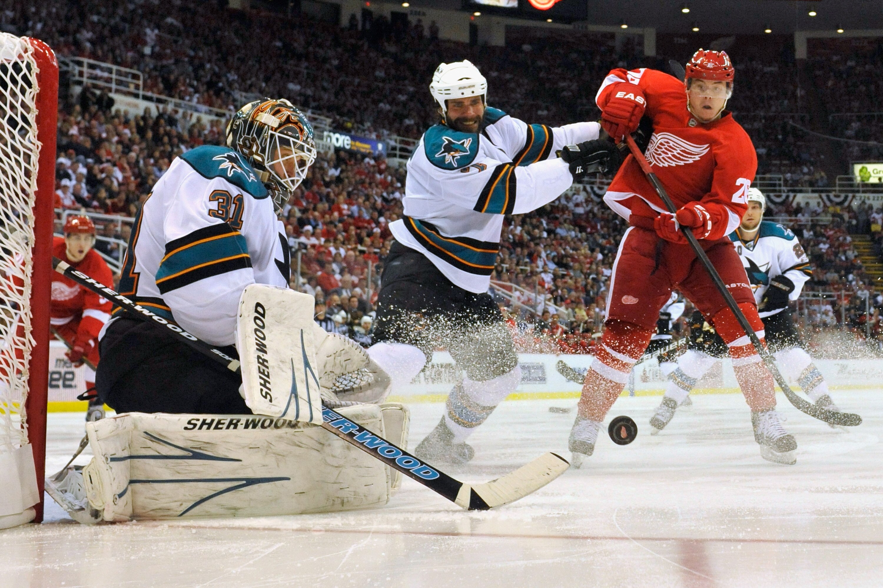 DETROIT - MAY 4:  Goaltender Antti Niemi #31 of the San Jose Sharks makes a save as Niclas Wallin #7 of the San Jose Sharks clears Jiri Hudler #26 of the Detroit Red Wings out of the crease in Game Three of the Western Conference Semifinals during the 201