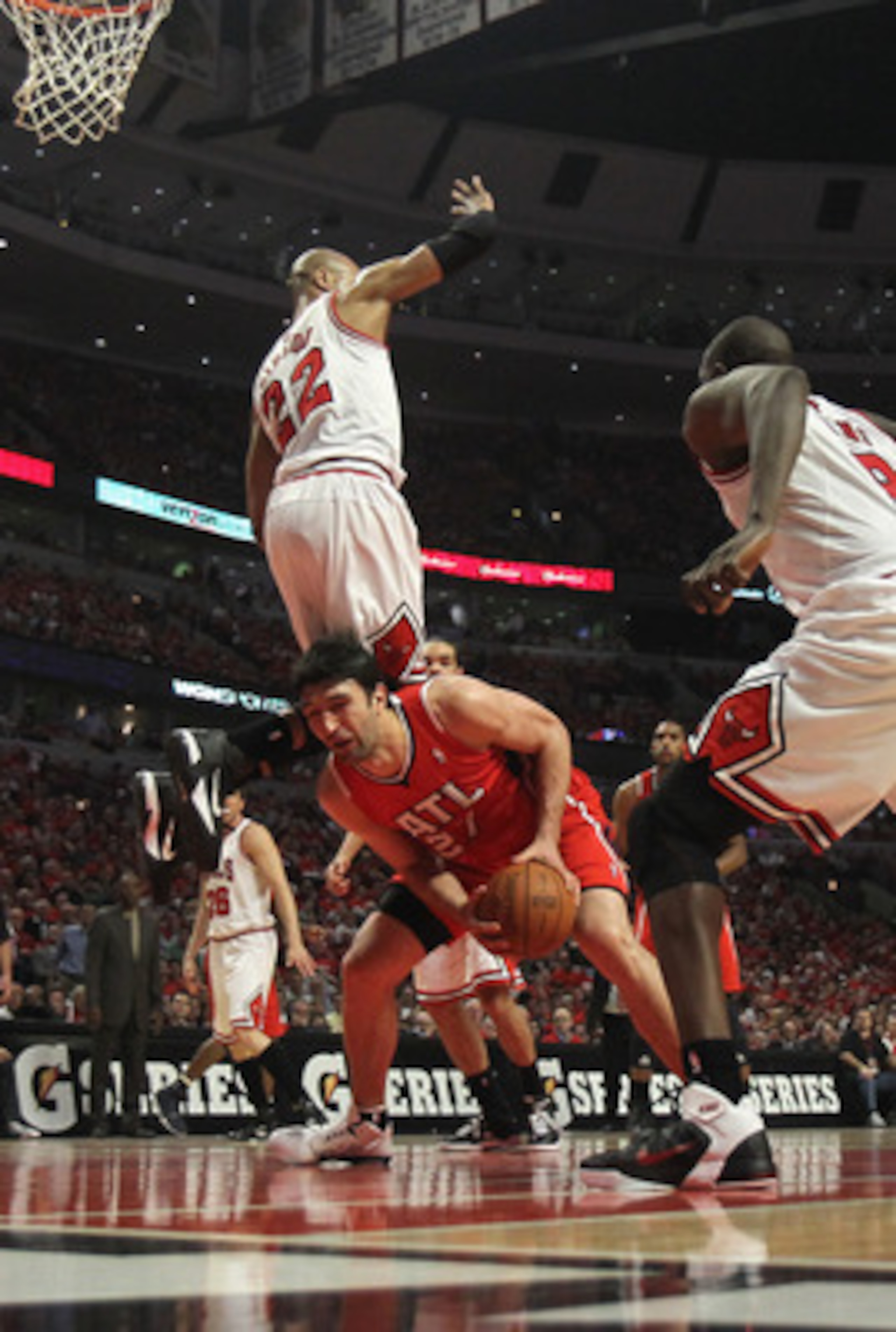 CHICAGO, IL - MAY 10: Taj Gibson #22 of the Chicago Bulls falls over Zaza Pachulia #27 of the Atlanta Hawks in Game Five of the Eastern Conference Semifinals in the 2011 NBA Playoffs at the United Center on May 10, 2011 in Chicago, Illinois. NOTE TO USER: