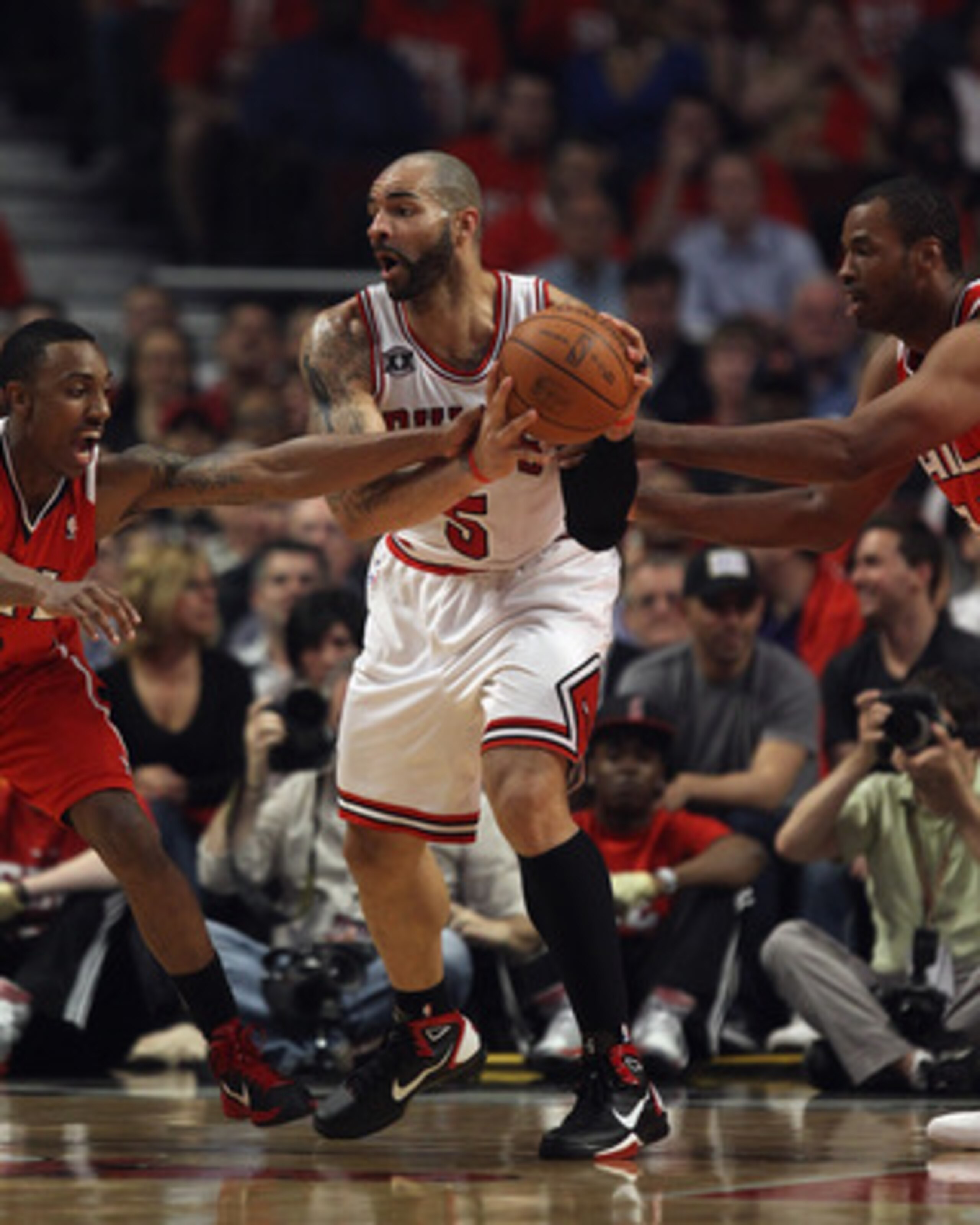 CHICAGO, IL - MAY 10: Carlos Boozer #5 of the Chicago Bulls looks to pass under pressure from Jeff Teague #0 (L) and Jason Collins #34 of the Atlanta Hawks in Game Five of the Eastern Conference Semifinals in the 2011 NBA Playoffs at the United Center on 