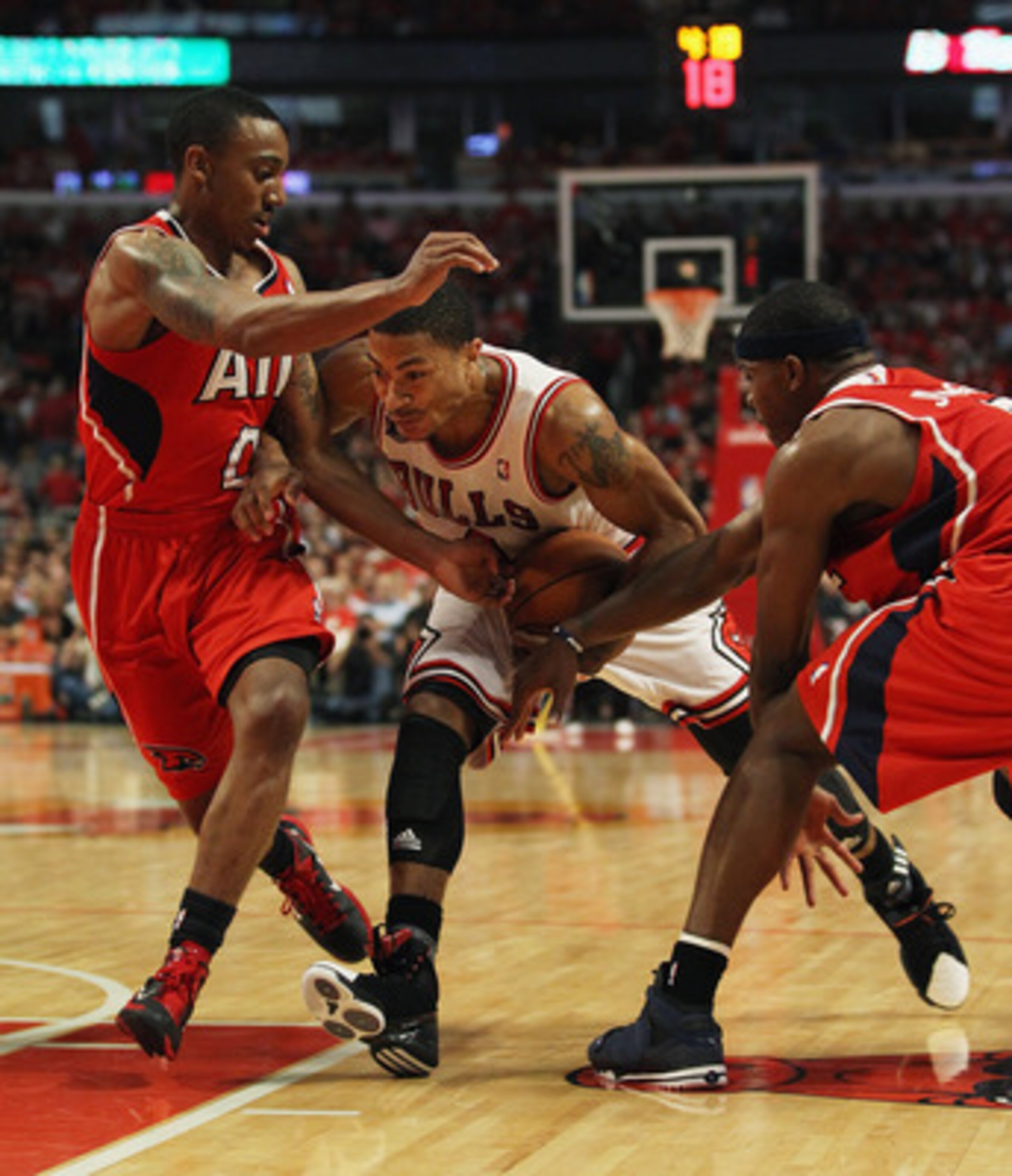 CHICAGO, IL - MAY 10: Derrick Rose #1 of the Chicago Bulls drives between Jeff Teague #0 (L) and Joe Johnson #2 of the Atlanta Hawks in Game Five of the Eastern Conference Semifinals in the 2011 NBA Playoffs at the United Center on May 10, 2011 in Chicago