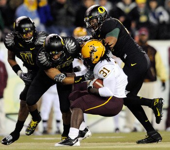 EUGENE,OR - NOVEMBER 14: Linebacker Eddie Pleasant #11, linebacker Spencer Paysinger #35 and linebacker Kenny Rowe #58 of the Oregon Ducks gang up to tackle running back Dimitri Nance #31of the Arizona State Sun Devils in the third quarter of the game at